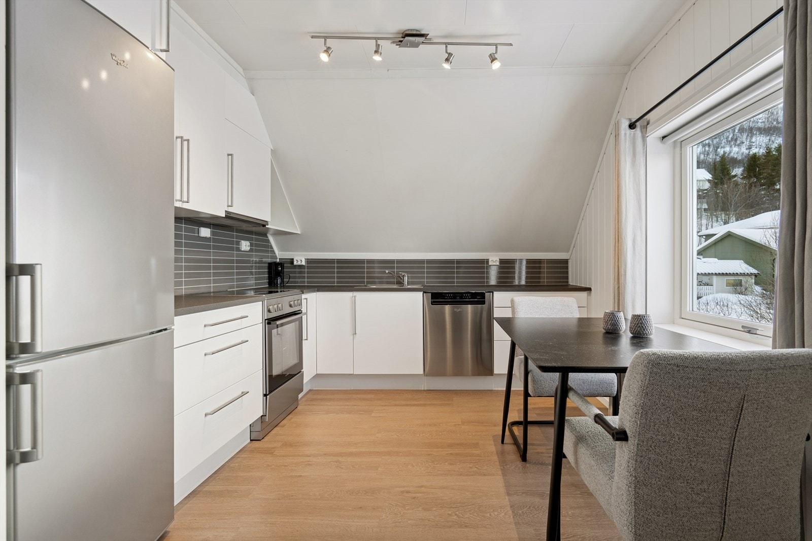 Kjøkkenet har en moderne innredning med glatte fronter, og det er avsatt plass til frittstående hvitevarer. Galleribilde