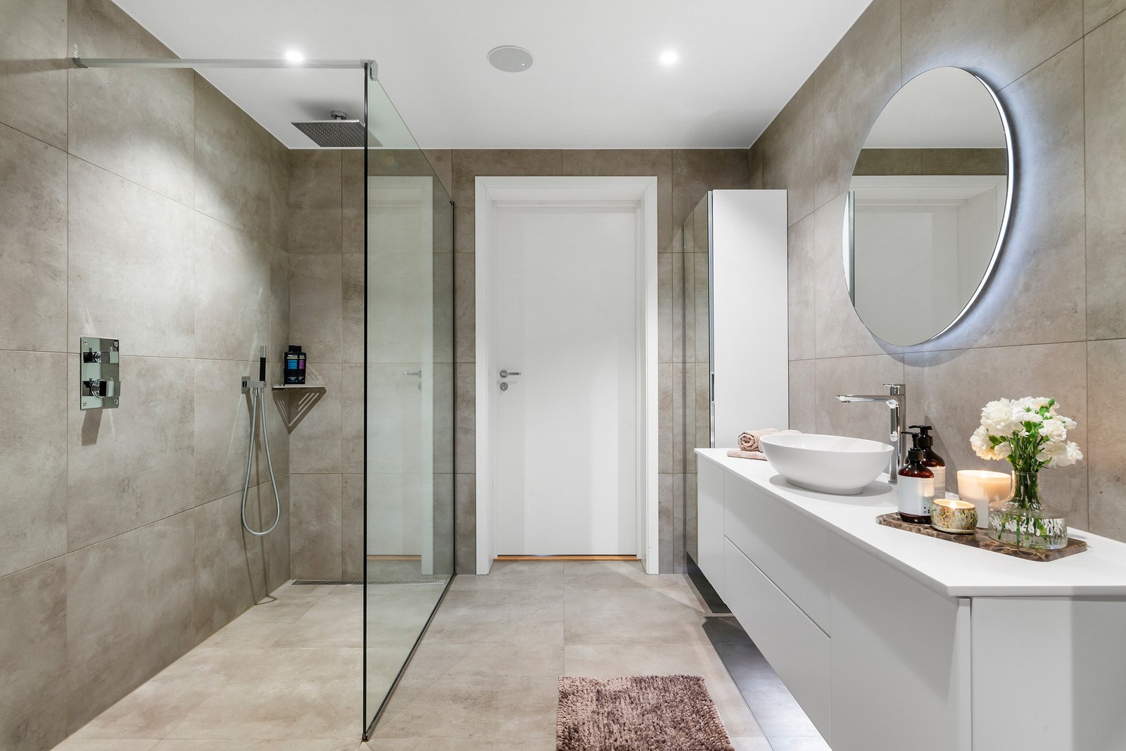 Badet i hovedetasjen er delikat med store fliser både på vegger og gulv, vannbåren gulvvarme, moderne garnityr i dusj og innfelt høytaler i himling. Galleribilde