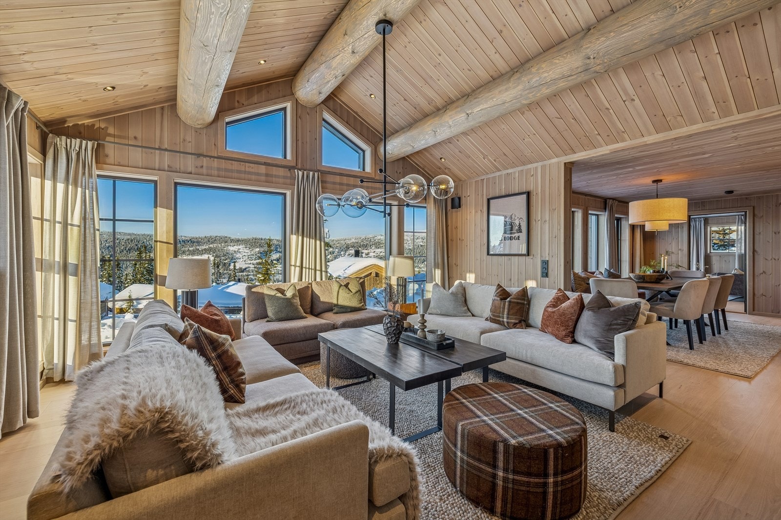 Store vindusflater og en imponerende takhøyde med synlige rundstokker preger hovedstuen. Galleribilde