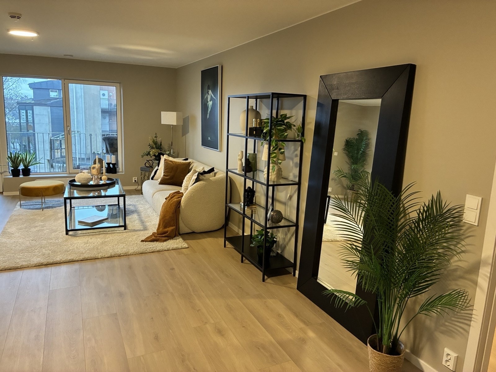 Lys og moderne stue med store vinduer som gir mye naturlig lys og en hyggelig atmosfære. Galleribilde