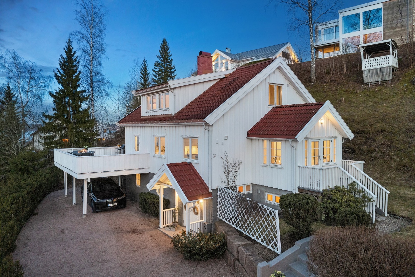Carport med el.bil-lader og oppkjørselen med plass til flere biler. Hyggelig paviljong øverst på tomten. Galleribilde