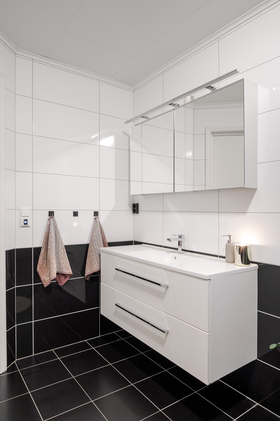 Badet er innredet med servant på innredning, toalett og dusjhjørne. Galleribilde