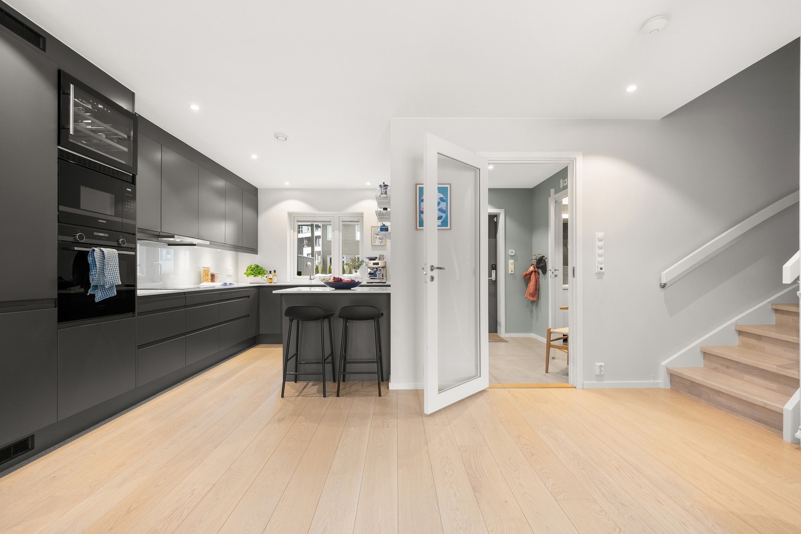 Boligens sosiale sone er meget innbydende med lyse, malte vegger og en-stavs parkettgulv. Galleribilde