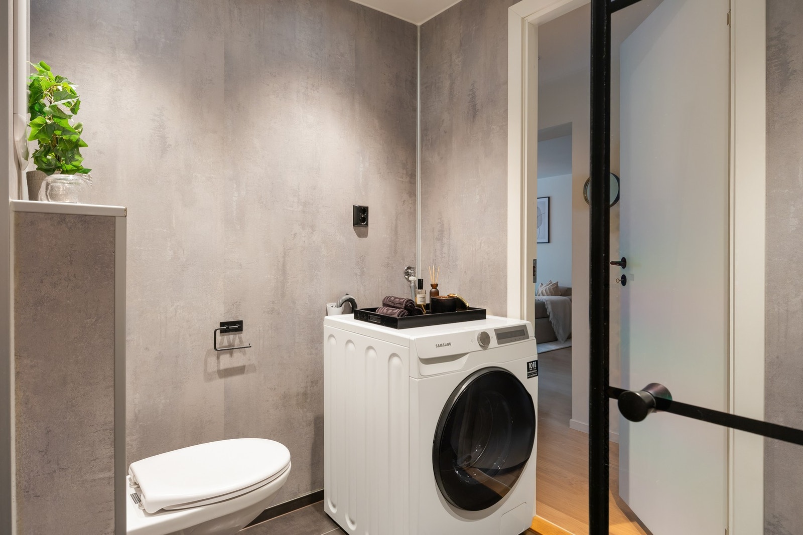 Her er baderomsinnredning, vegghengt toalett, dusjhjørne og opplegg for vaskemaskin. Varmekabler i gulv. Galleribilde