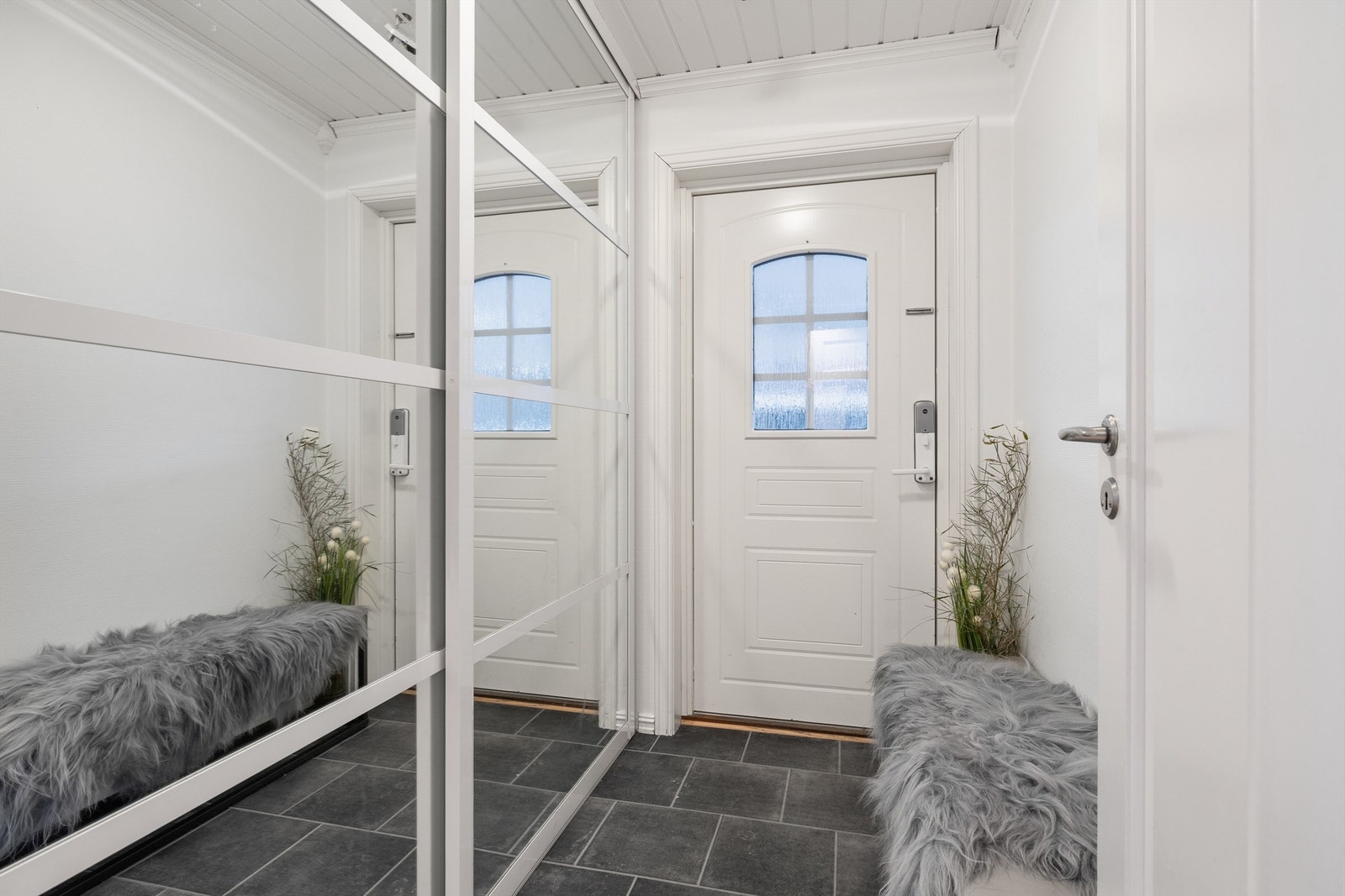Lys og romslig entre med skyvedørsgarderobe Galleribilde