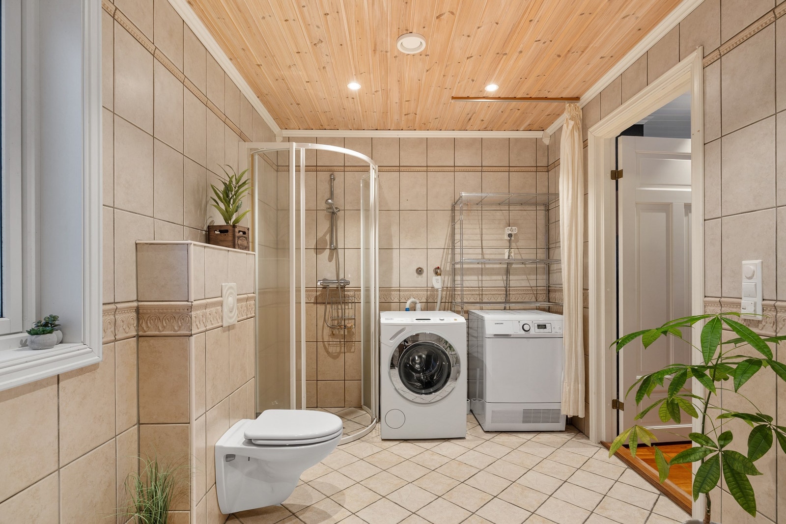 I tillegg til badekar er her dusj og opplegg for tørketrommel og vaskemaskin Galleribilde