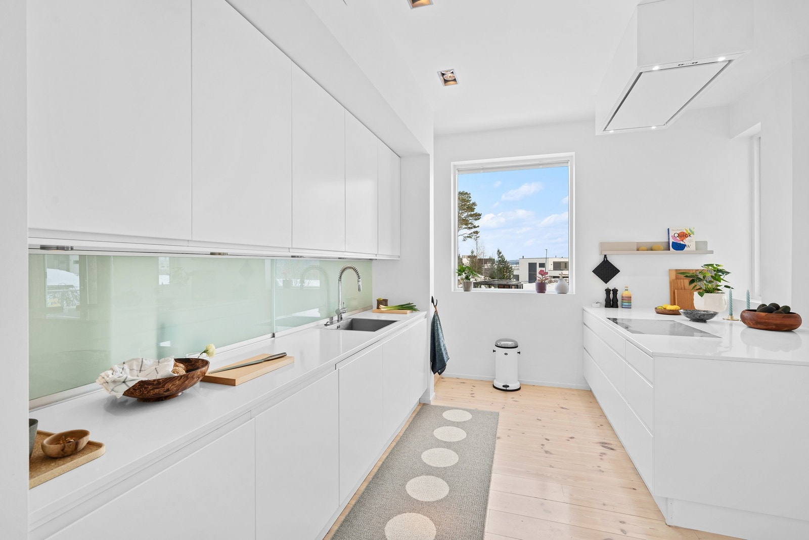 Bak glasset mellom benkeplaten og overskapene har man oppbevaringsplass - perfekt for å gjemme unna det man ikke ønsker at skal stå fremme til enhver tid. Solid benkeplate i kompositt. Vask med uttrekkbar spylefunksjon. Galleribilde