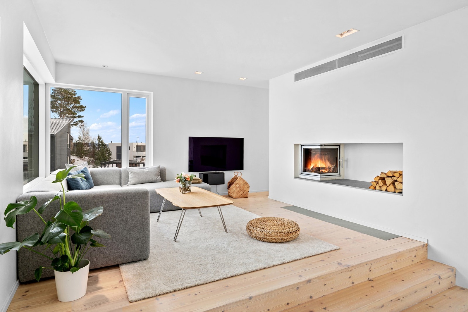 Flott peisinnsats i denne delen av stua, som varmer godt på vinterstid. Ellers er det integrert luft-til-luft varmepumpe i veggen (bak risten øverst på veggen). Galleribilde