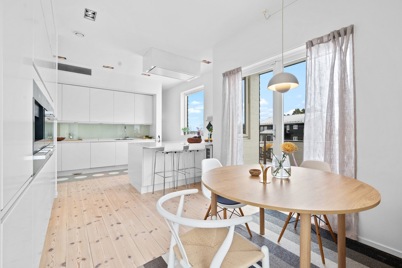 Videre har boligen også et stilrent og flott kjøkken. Det er et gjennomgående lyst, lett og samtidig lunt preg i hele boligen. Her har man også plass til kjøkkenbord, samt barløsning ved kjøkkenøya. Galleribilde