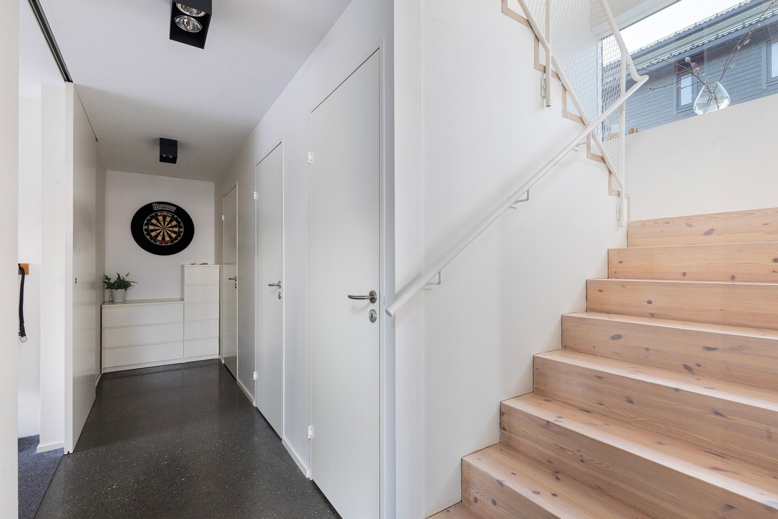 Underetasjen: idet man kommer ned trappa blir man møtt av en romslig gang. Flott og rustikk betonggulv i gangen - en fin kontrast mot trappen i heltre furu. Galleribilde