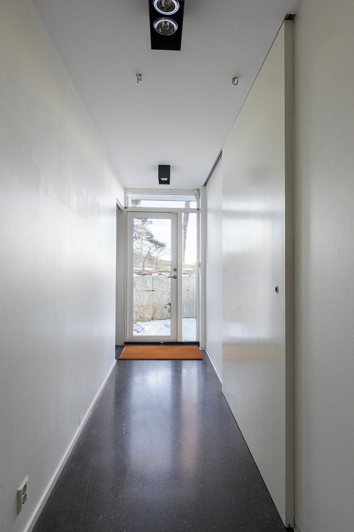 Gjennomlyset er også godt ivaretatt i underetasjen. Utgang til terrasse/uteplass i enden av gangen. På høyre side av gangen ligger tre gode soverom. Ellers i etasjen finnes et stort bad, eget vaskerom og boder. Galleribilde