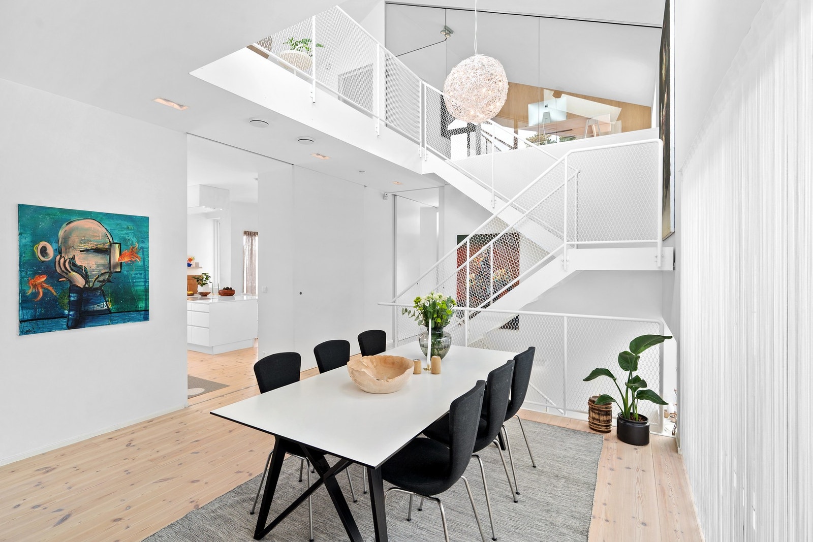 Spisestuen ligger praktisk plassert mellom stue og kjøkken. Trappen blir som et møbel i rommet, med sitt flotte utrykk og luftige utførelse. Denne er spesialbygget til huset, og er laget av stål. Galleribilde