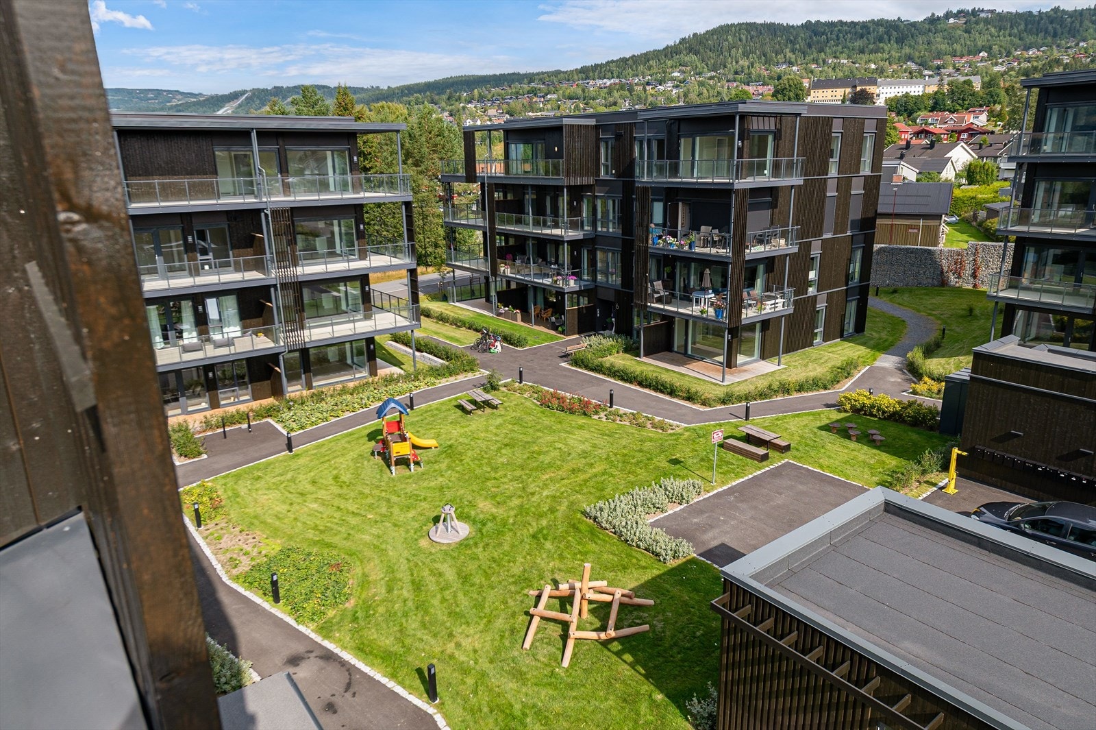 Sameiets tomt er pent opparbeidet med plenarealer, asfalterte gangveier, belysning og diverse beplantning. Galleribilde