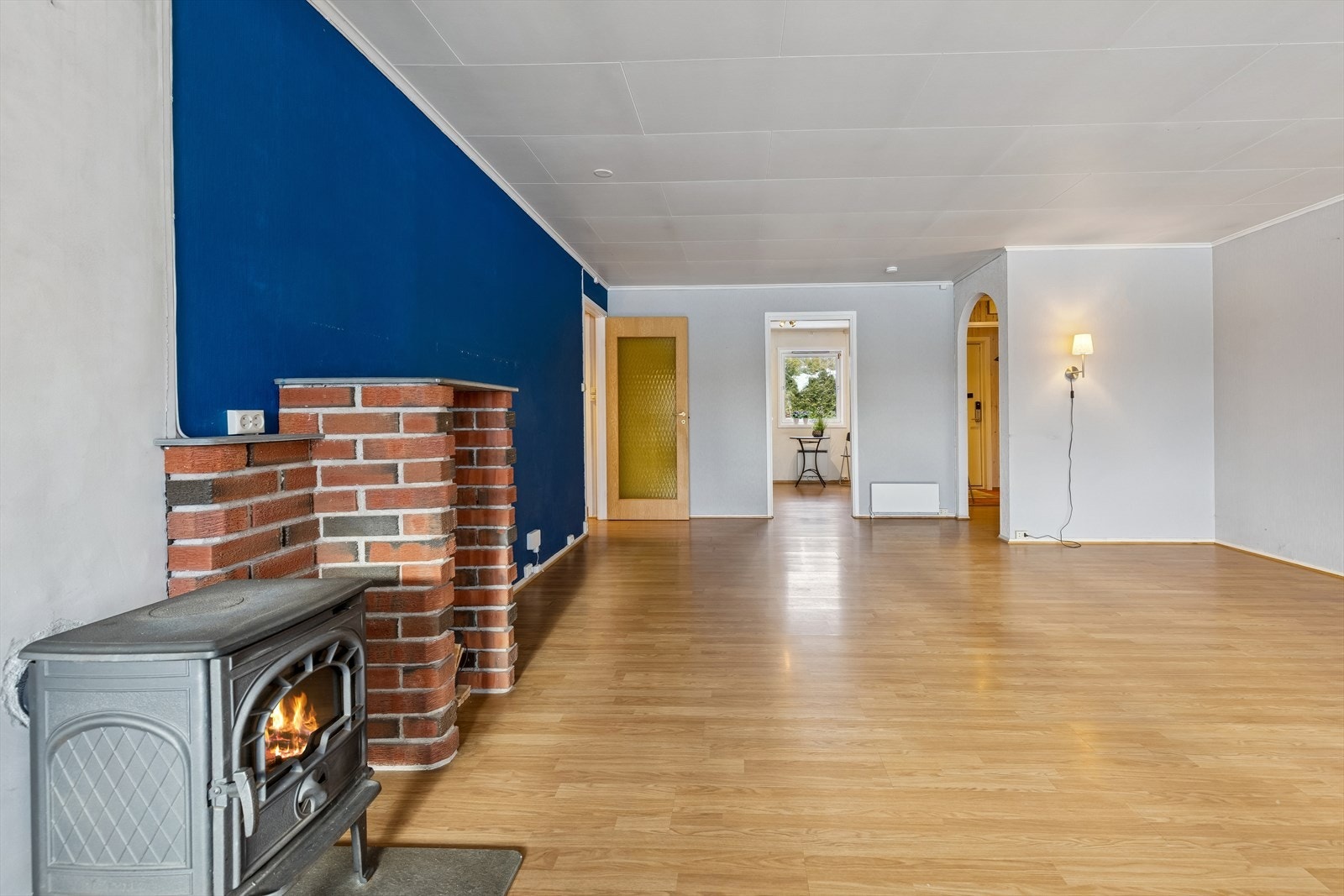 Stuen har laminat på gulvet og vegger med trepanel, tapet og malte plater. Galleribilde