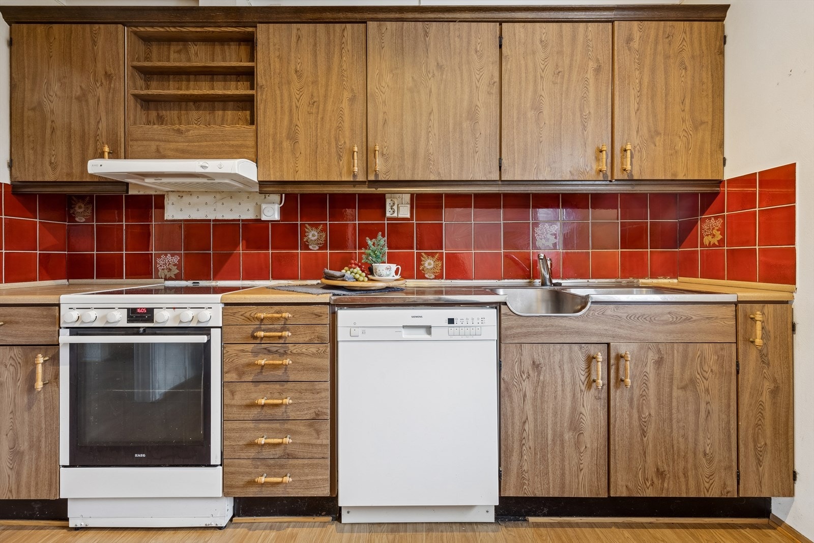 Kjøkkenet har en innredning med glatte fronter og benkeplater i laminat og stål. Galleribilde