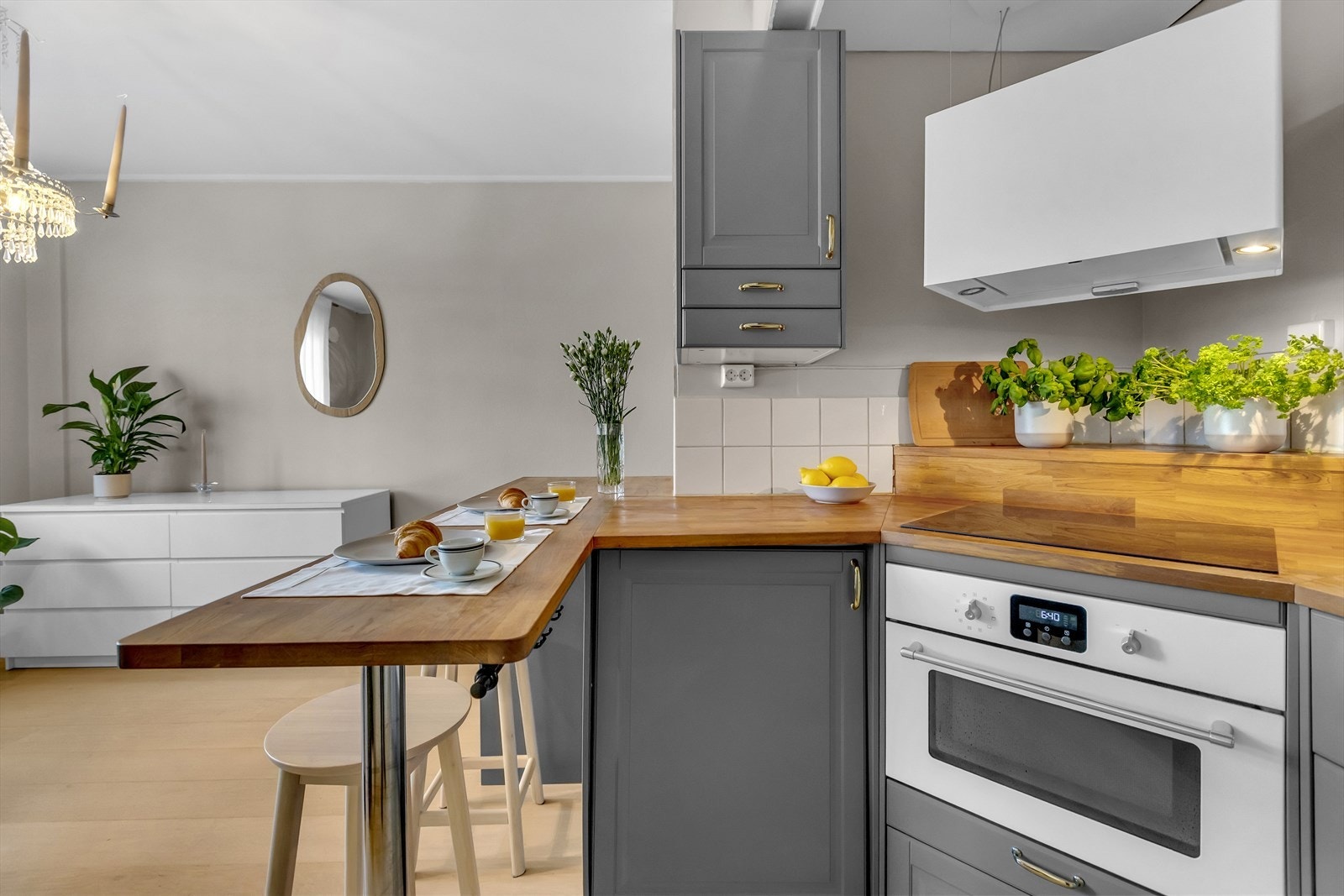 Den praktiske kjøkkenøyen fungerer både som arbeidsbenk og spiseplass, og bidrar til en sosial og funksjonell romløsning. Galleribilde