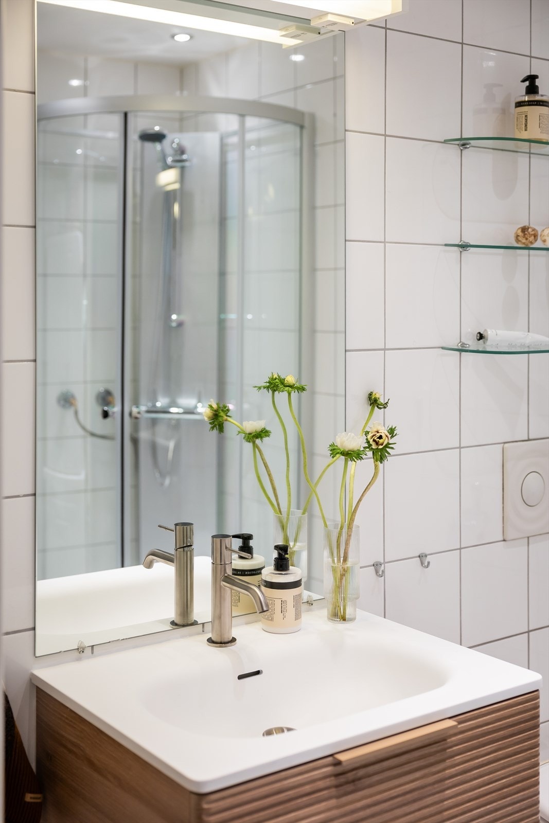 Speil og lysarmatur på vegg over servant. Galleribilde