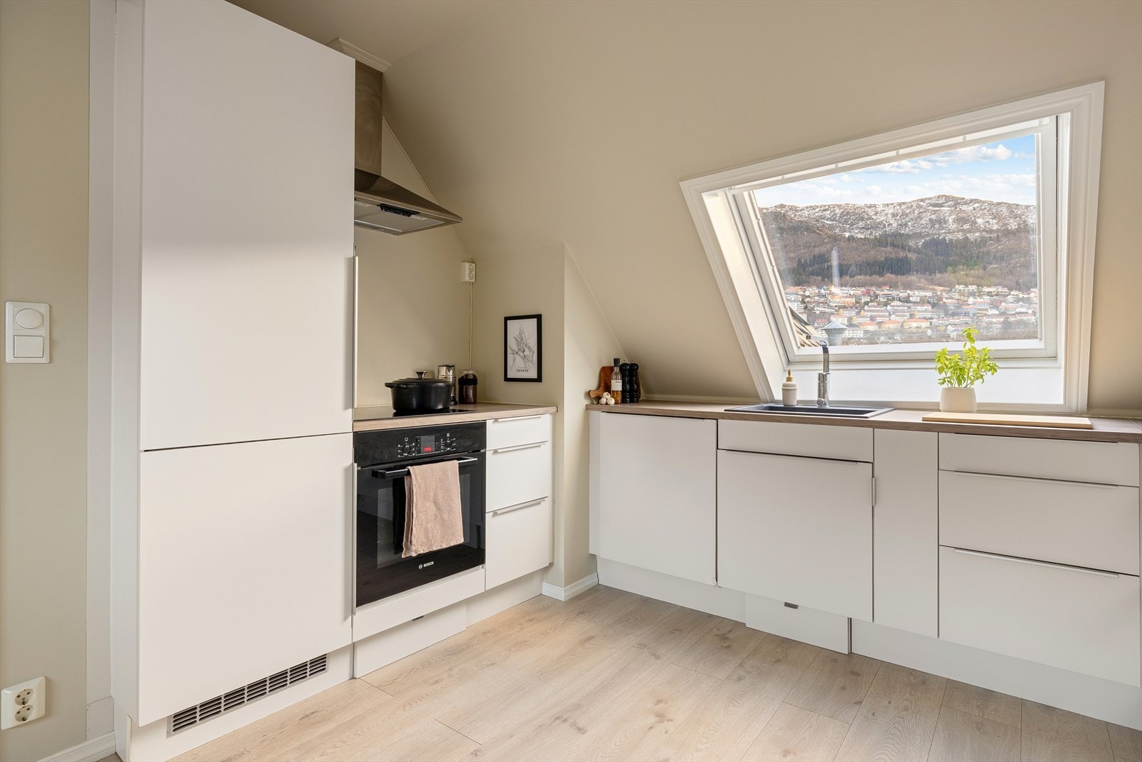 Her får du god benkeplass og rikelig med oppbevaring, som gjør matlaging både effektiv og hyggelig. Integrerte hvitevarer bidrar til et helhetlig og ryddig uttrykk på kjøkkenet. Galleribilde