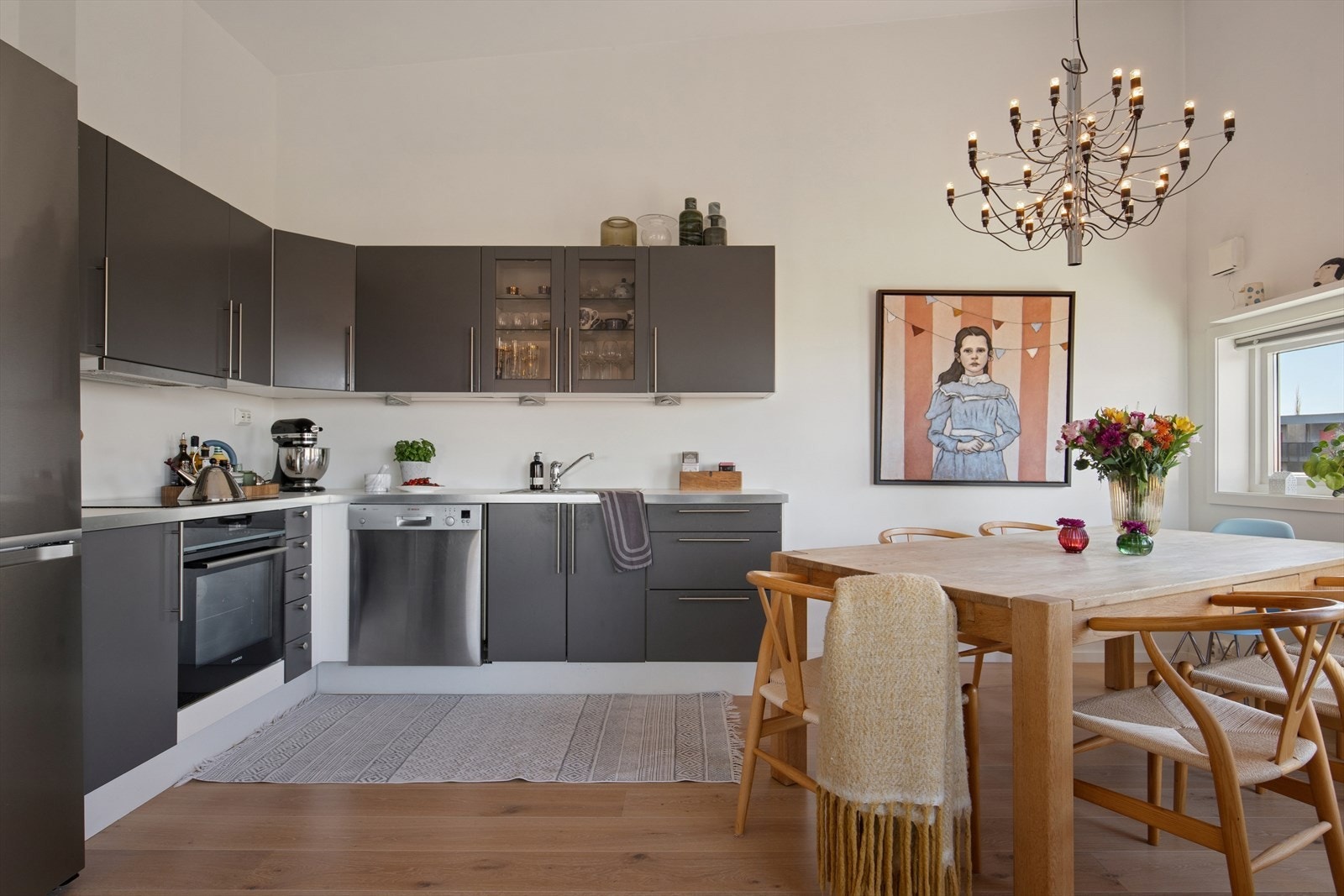 Kjøkkenet er stilrent innredet med grå, slette fronter og hvit benkeplate i laminat. Et romslig kjøkken hvor man har godt med skap- og skuffeplass, samt gode arbeidsflater på benk. Galleribilde