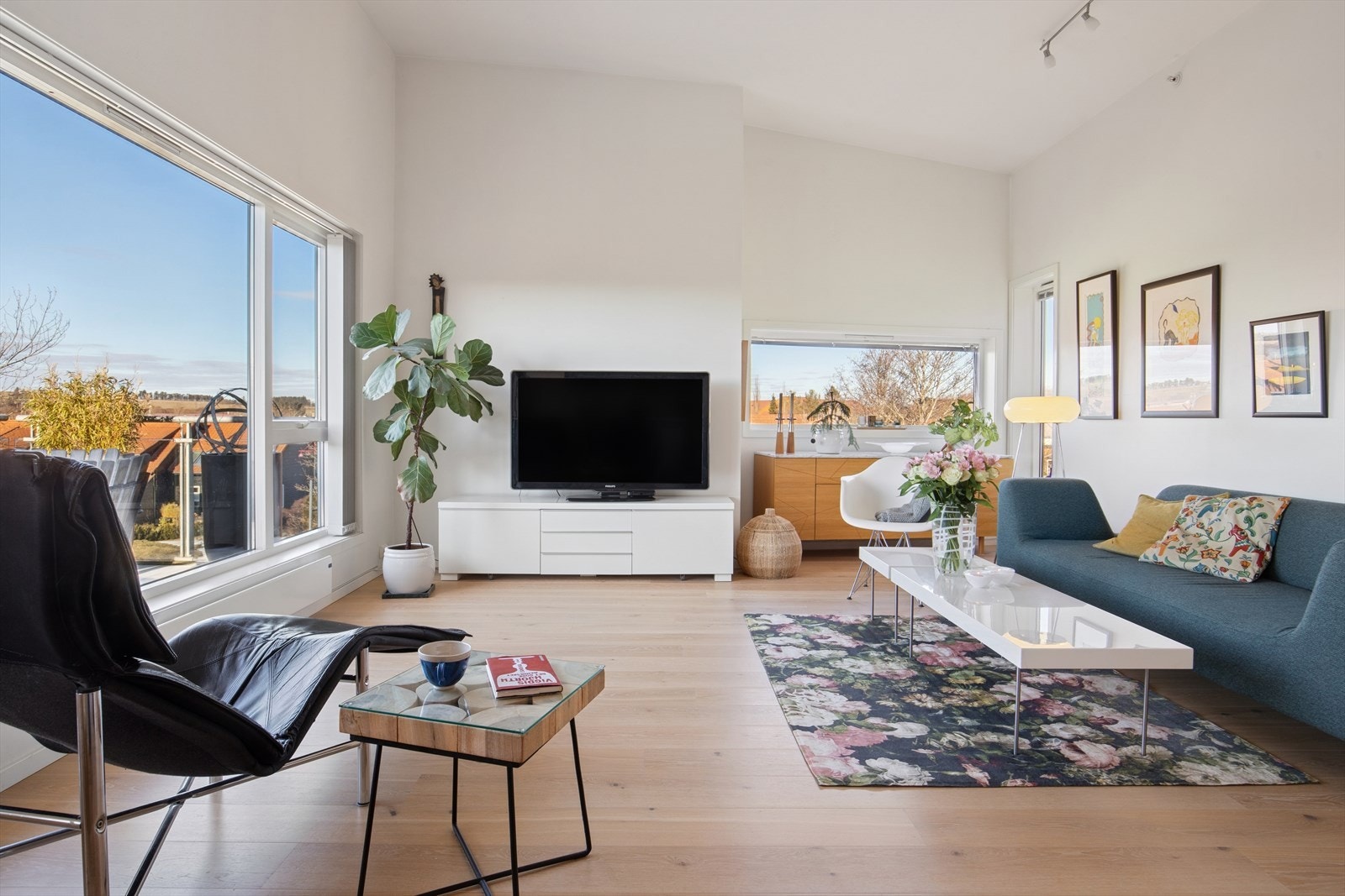 Stue og kjøkken ligger i åpen løsning. Et lyst og innbydende rom med store vindusflater som gir rikelig med naturlig lys og sammen med den gode takhøyden gir en svært god romfølelse. Galleribilde