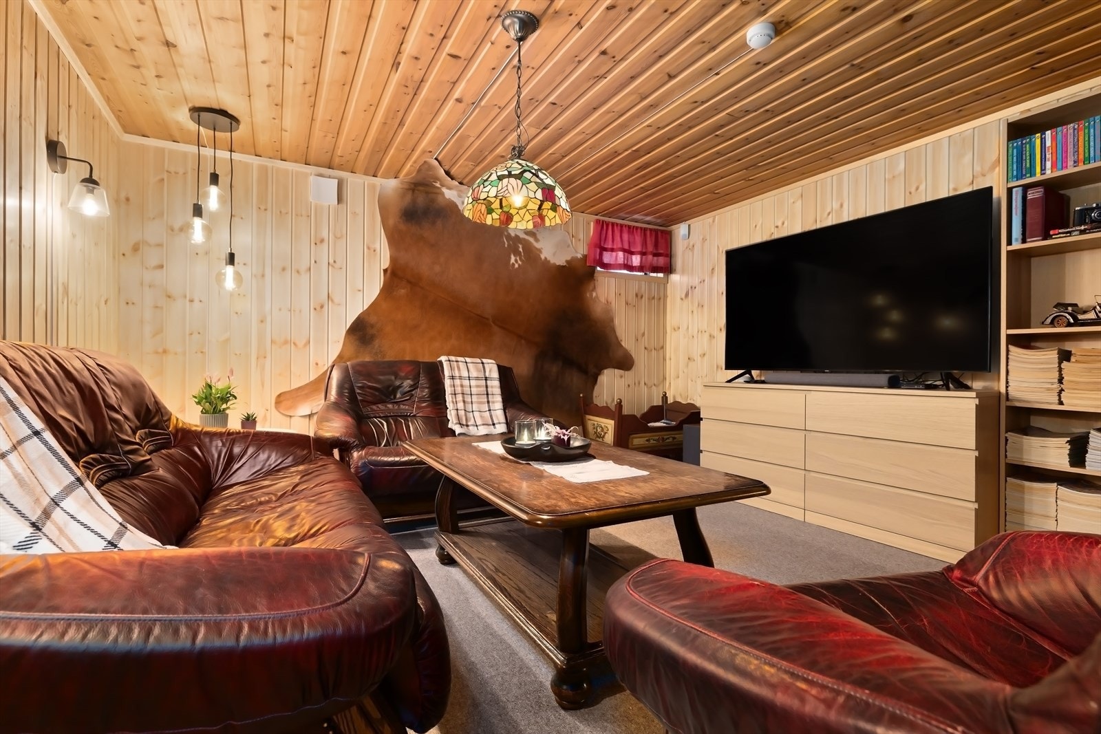 Det andre disponible rommet kan fint benyttes som kjellerstue, perfekt for sosiale sammenkomster. Galleribilde