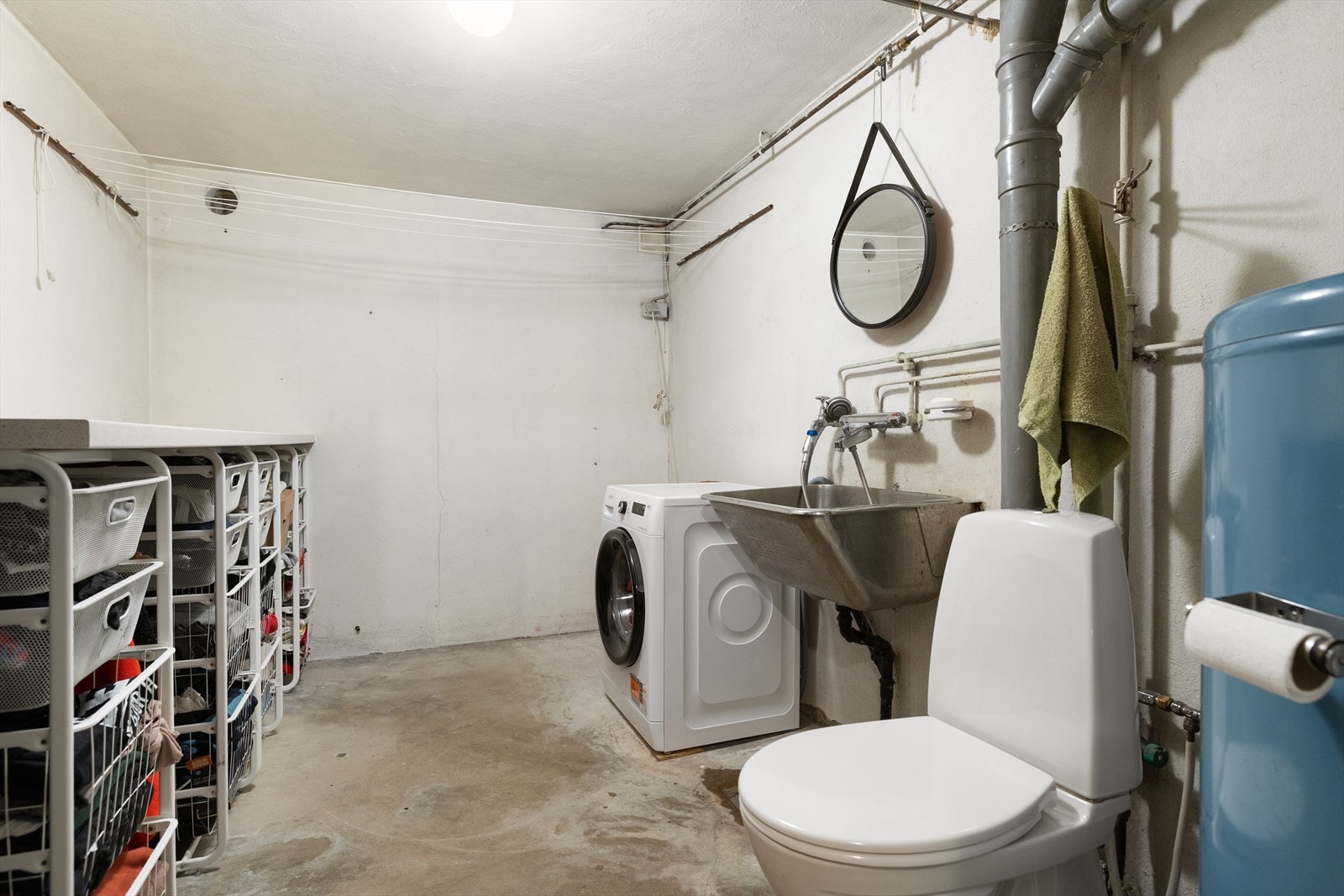 Praktisk vaskerom med toalett, utslagsvask og opplegg for vaskemaskin. Galleribilde