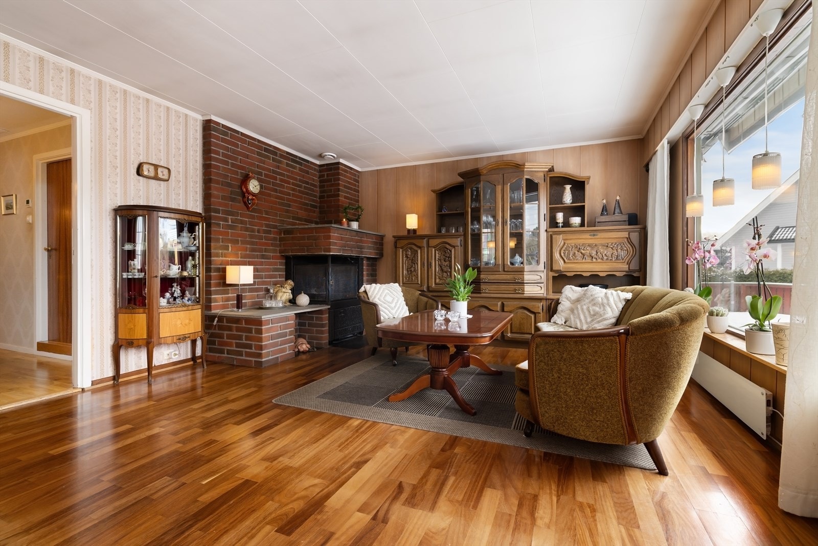 Stuen er et sentralt samlingspunkt med en stemningsfull teglsteinspeis. Galleribilde