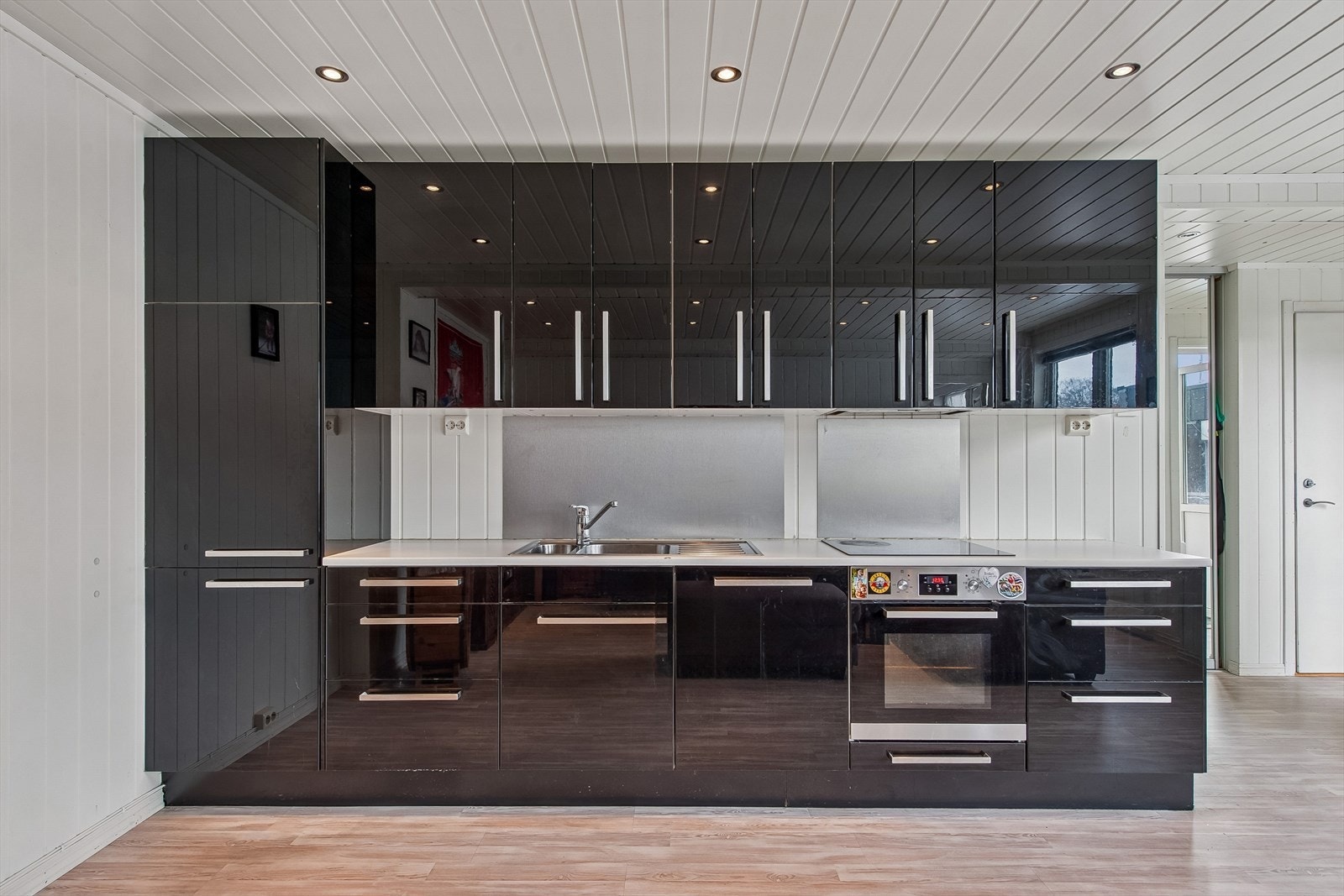 Kjøkkenet har en moderne innredning med høyglans fronter og integrerte hvitevarer. Galleribilde