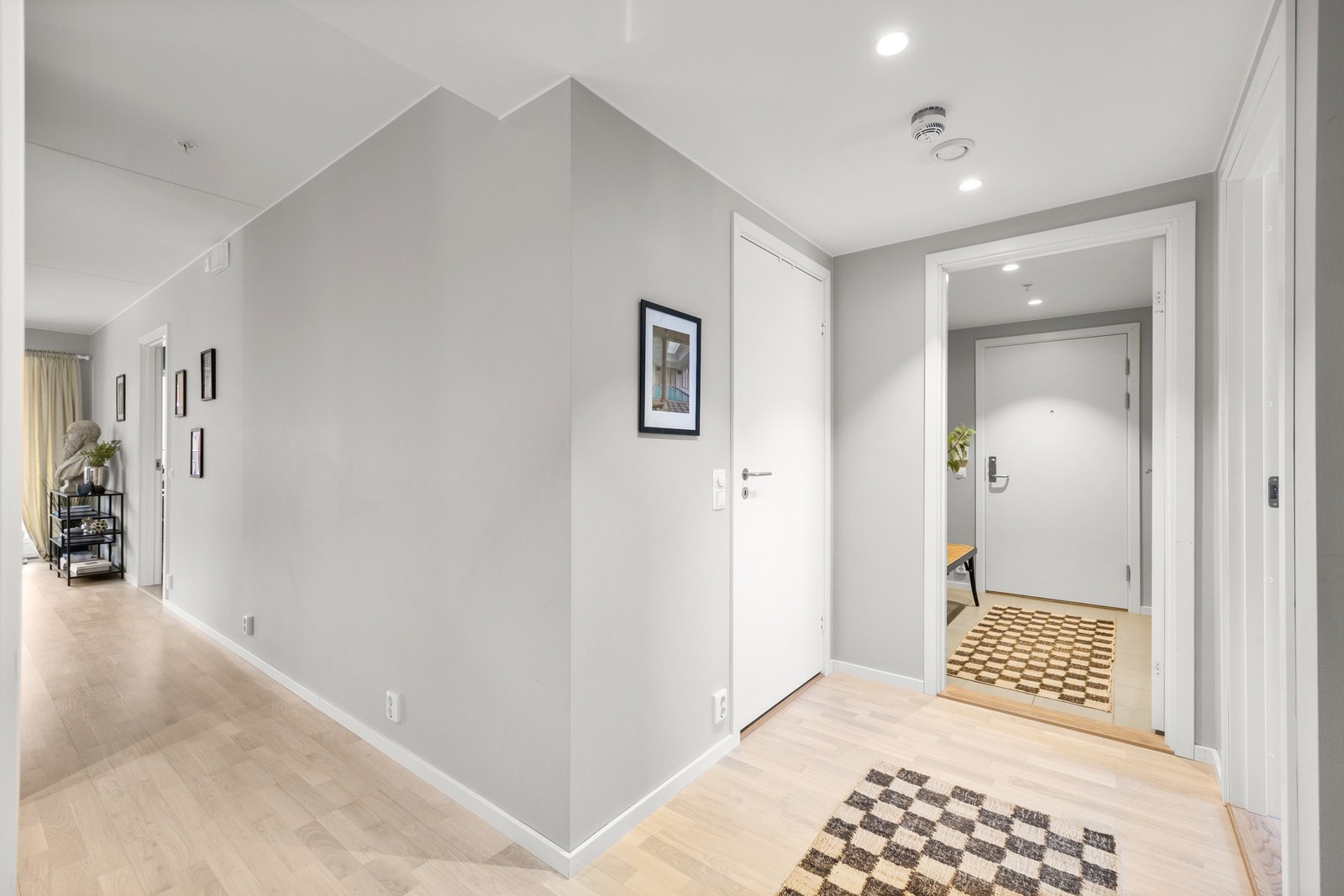 Romslig entré/gang med flere dører og gode forbindelser til boligens øvrige rom. En funksjonell løsning som skaper en naturlig inndeling av sonene. Galleribilde