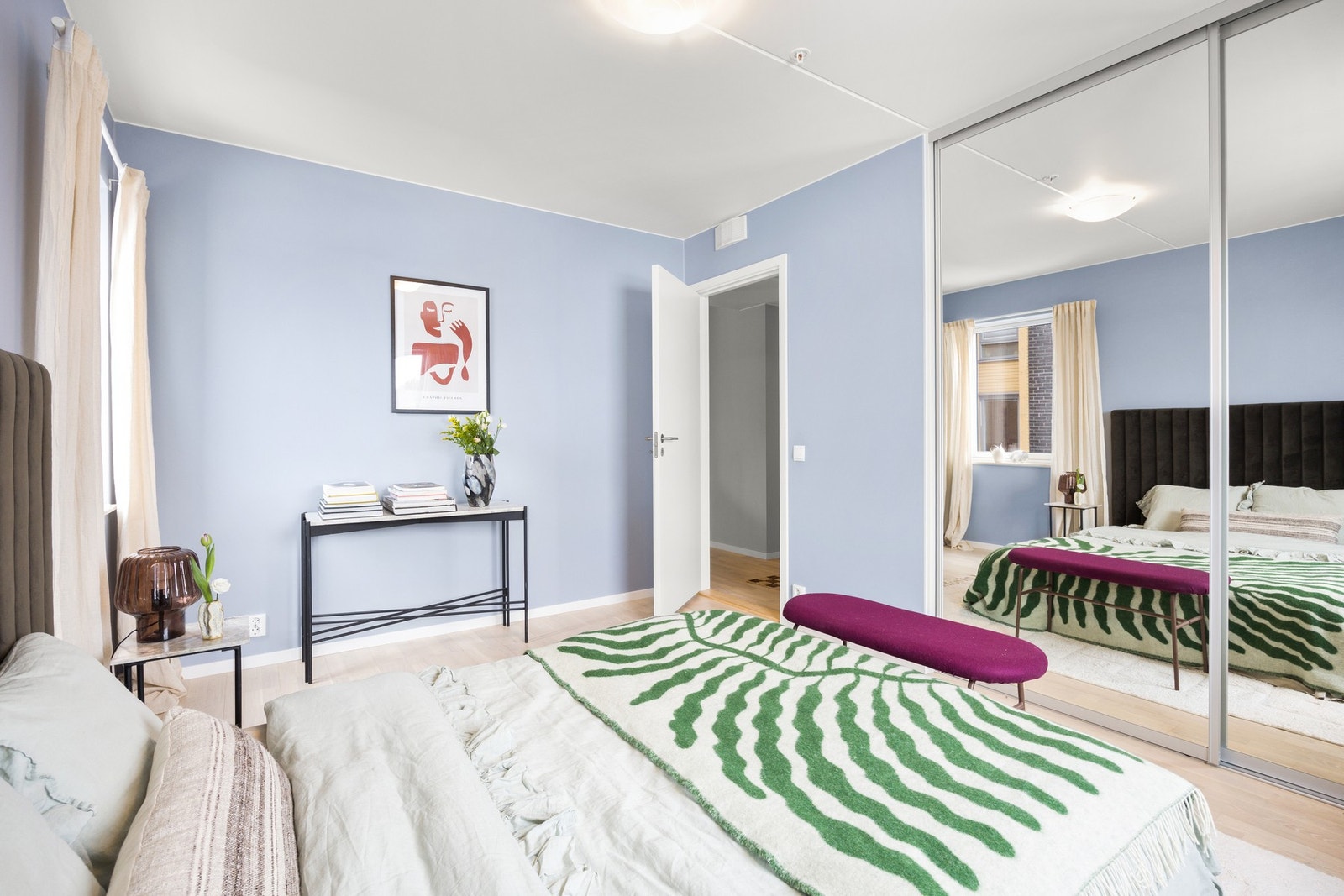 Romslig soverom med skyvedørsgarderobe med speilfronter som gir praktisk oppbevaring og bidrar til en luftig romfølelse. Galleribilde