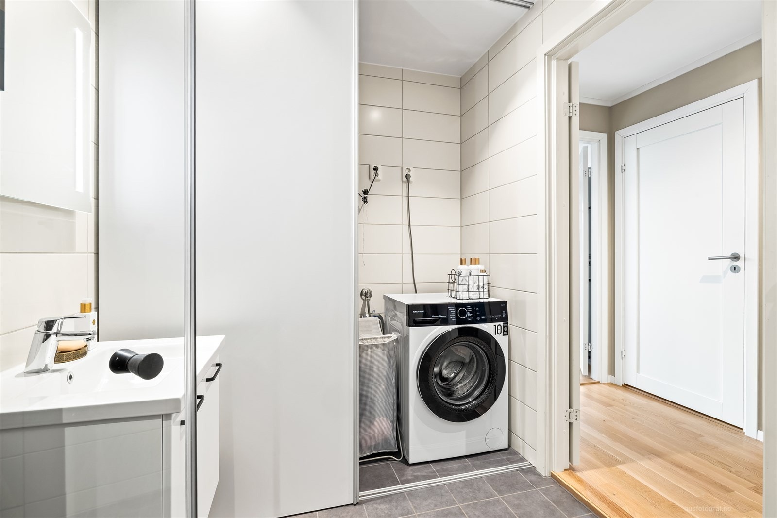 Rommet har opplegg for vaskemaskin og tørketrommel, praktisk skjult med skyvedører. Galleribilde