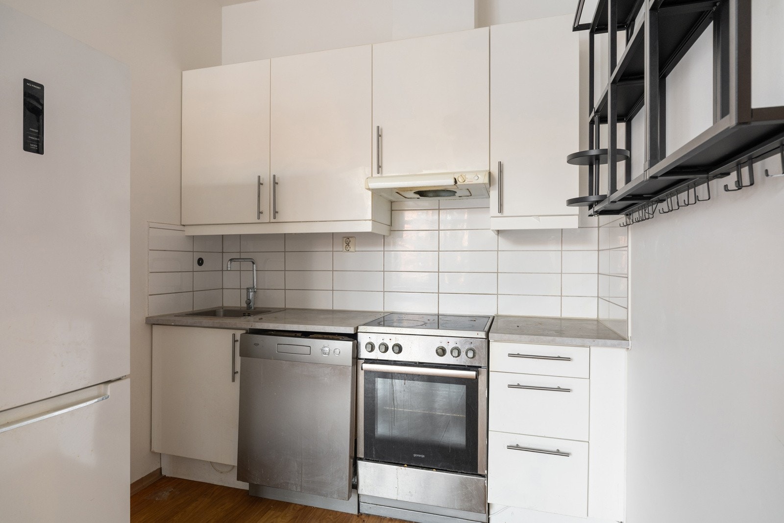 Lys kjøkkeninnredning fra 2011 med hvite glatte fronter, laminert benkeplate med nedfelt oppvaskkum og fliser i benkeryggen. Kjøkkenet er utstyrt med hvitevarer som medfølger i handelen. Galleribilde