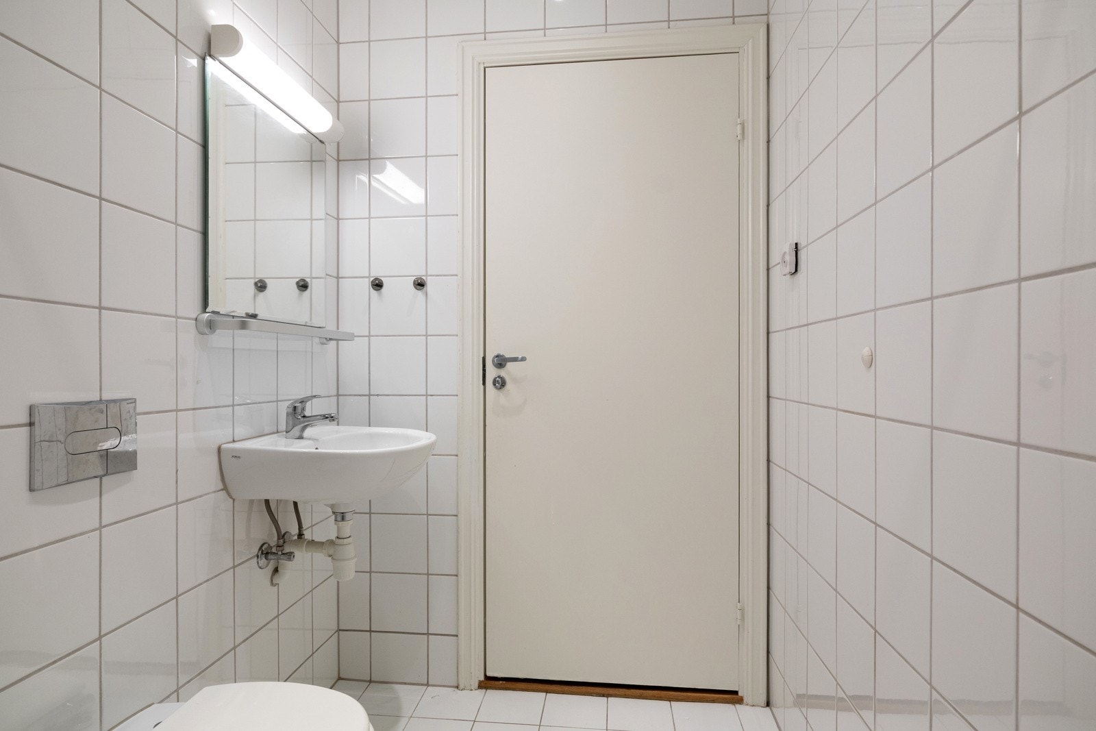 Baderommet er utstyrt med vegghengt servant med speil og belysning over, dusjhjørne med forheng, vegghengt toalett og opplegg for vaskemaskin. Galleribilde