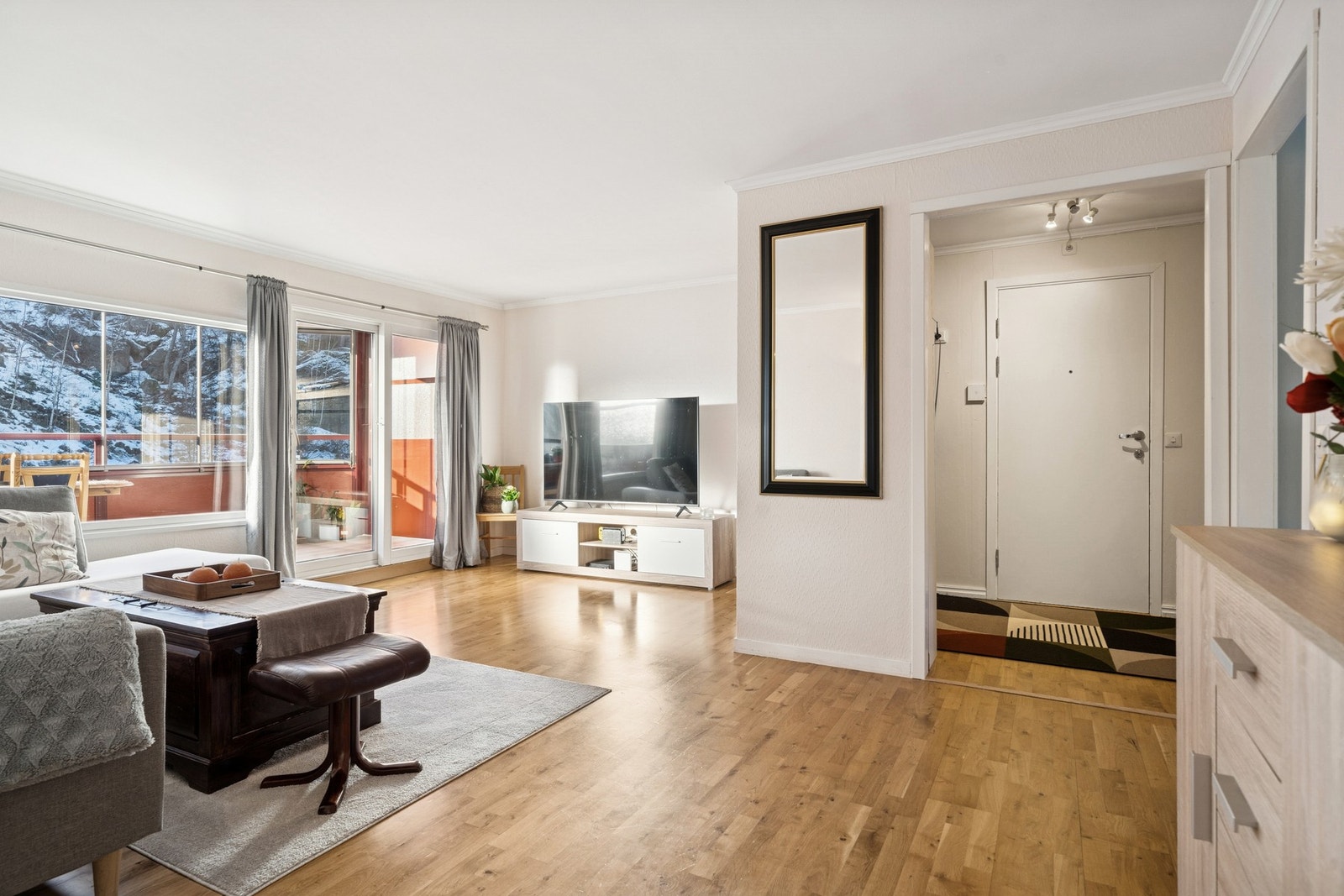 Store vinduer gir utsyn mot grøntområde og fjellknauser. Galleribilde