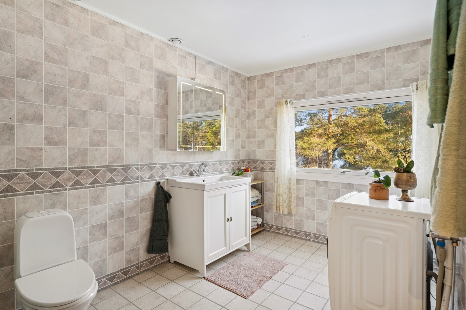 Romslig bad med flislagte vegger og gulv. Galleribilde