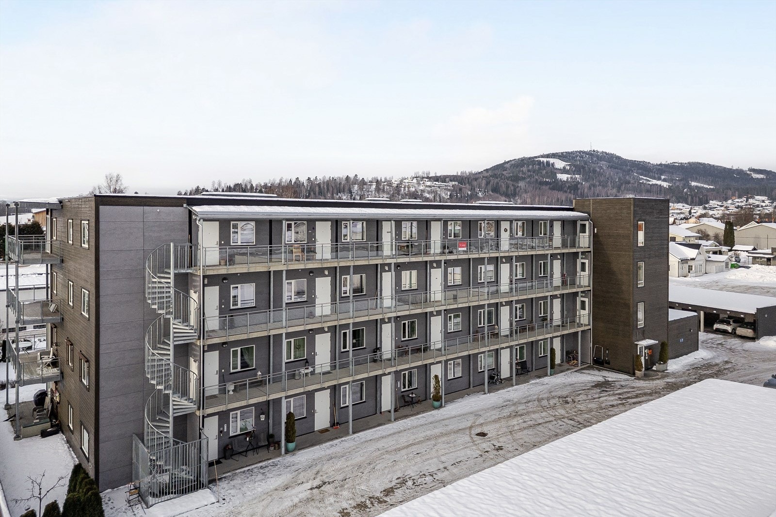 Bakgård med asfalterte områder, carportanlegg og boder. Galleribilde