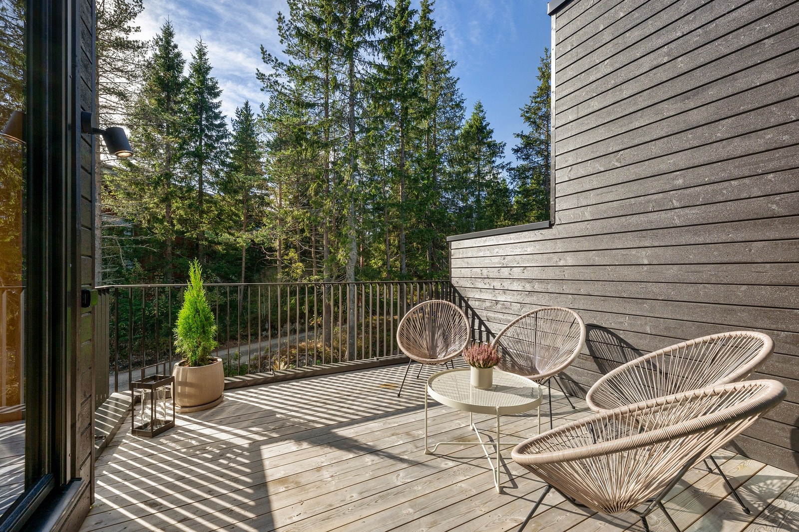 En uteplass som gjør boligen større i praksis: når døren står åpen, oppleves verandaen som en naturlig del av oppholdsrommet. Galleribilde