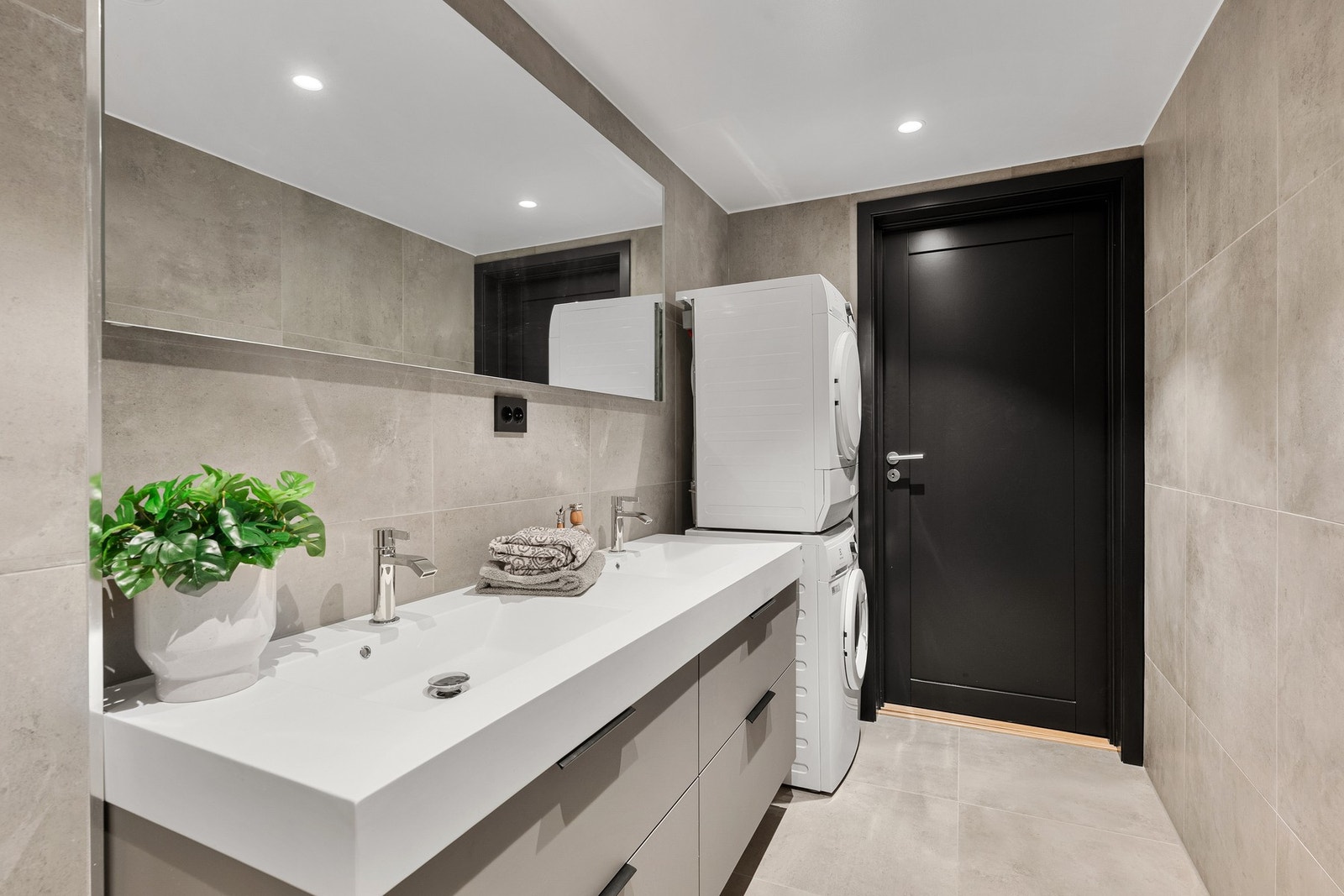 Badet kombinerer komfort og funksjon med elektrisk, termostatstyrt gulvvarme, regnfallsdusj og vegghengt toalett med spyle- og tørkefunksjon. Galleribilde