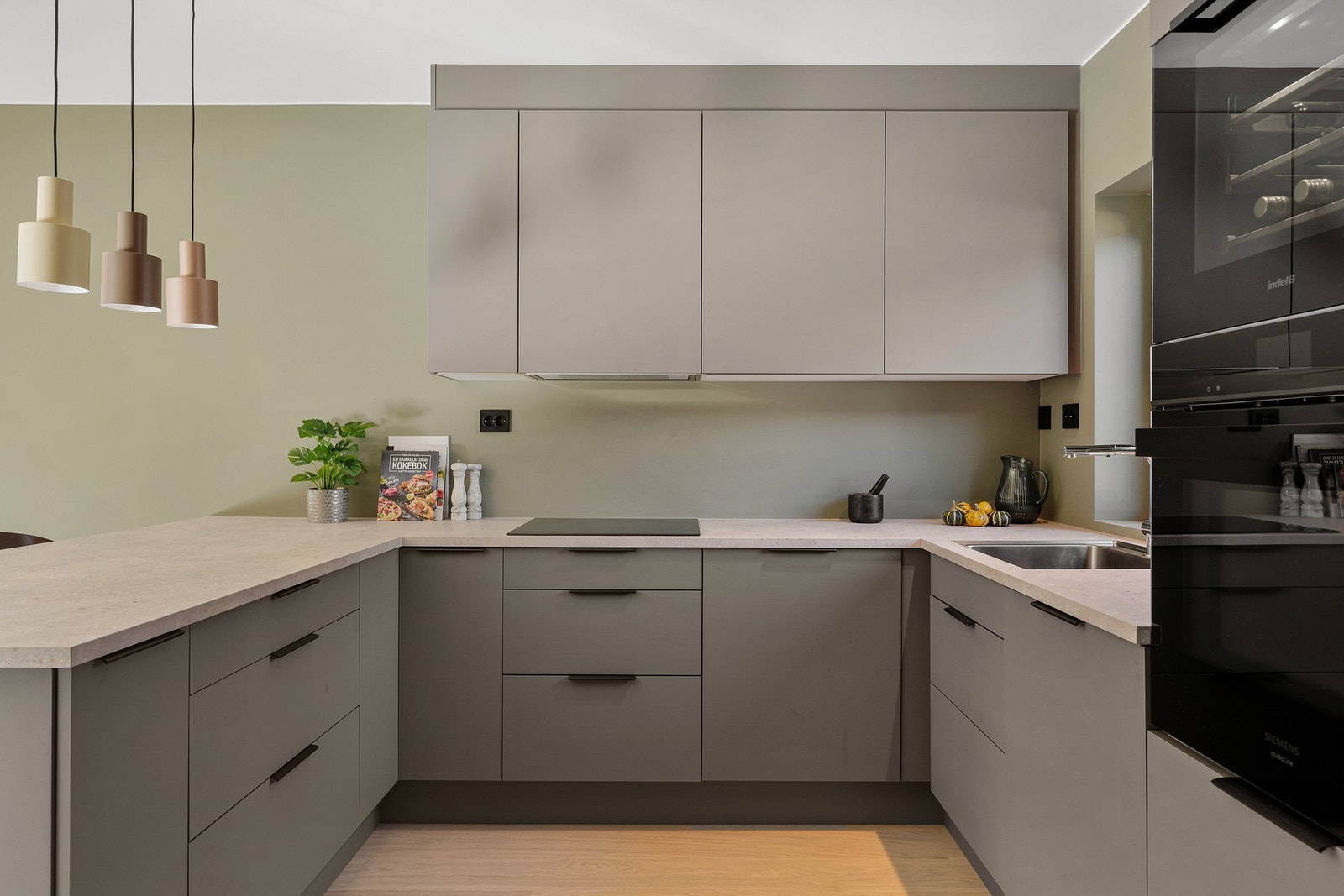 Slette fronter i fargen Mørk sand som gir et rent og moderne uttrykk, kombinert med en slitesterk laminat benkeplate og planlimt oppvaskkum i rustfritt stål. Galleribilde