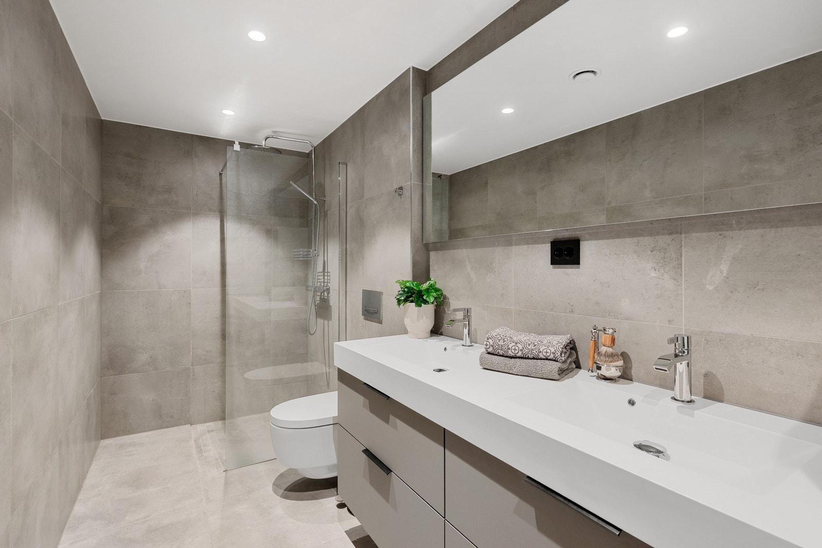 Hovedbadet i underetasjen er flislagt og har en praktisk og romslig løsning med dobbel servant, speilskap med lys og opplegg for både vaskemaskin og tørketrommel. Galleribilde