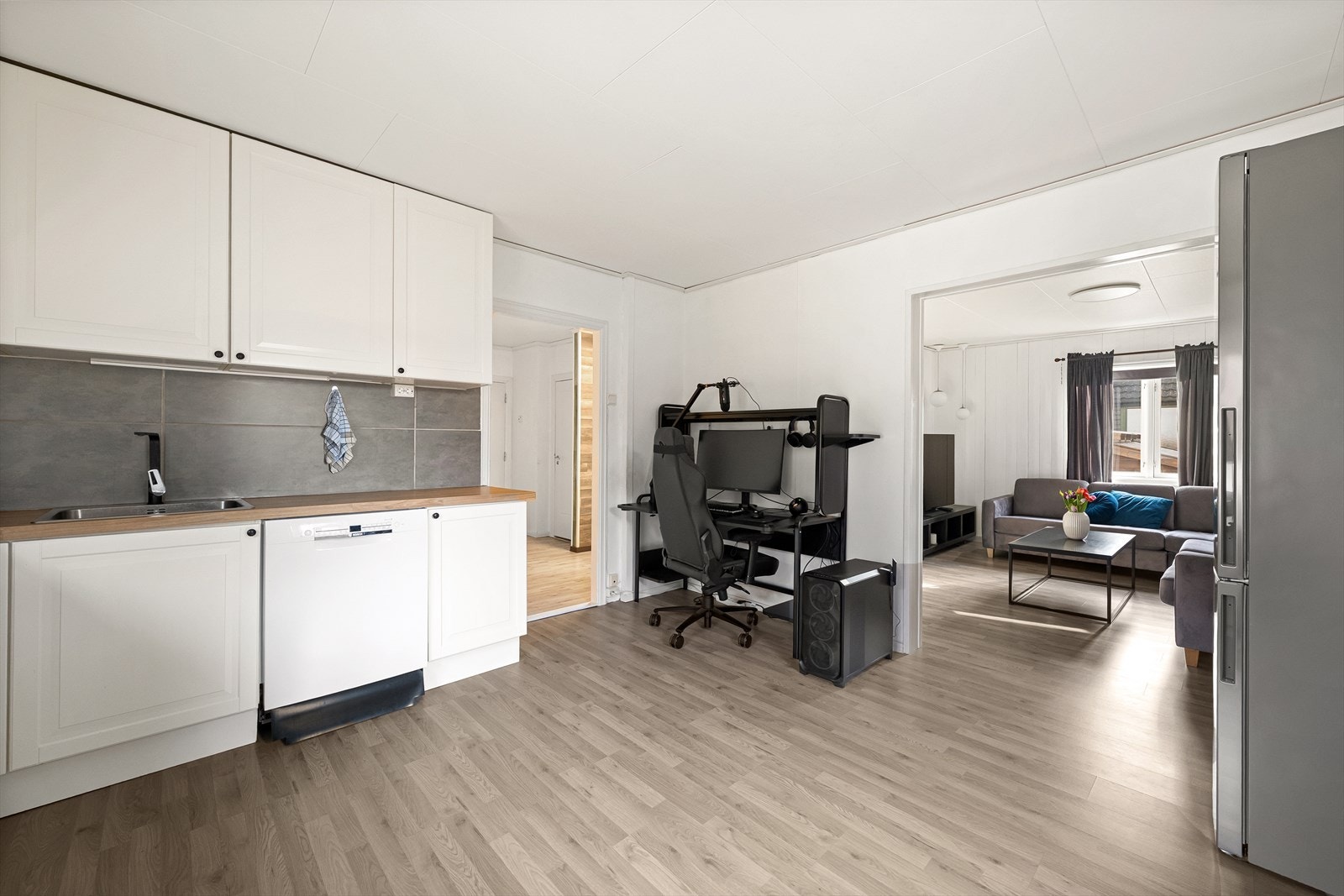 Mellom kjøkkenet og stuen er det en praktisk løsning som skiller rommene, noe som gir mulighet til enkelt å innrede et kontorhjørne Galleribilde