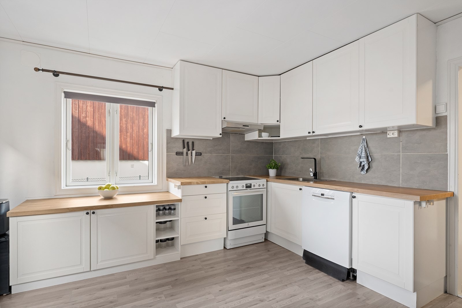 Velholdt kjøkken med nyere benkeplate og overskap som gir ekstra lagringsplass og god funksjonalitet Galleribilde