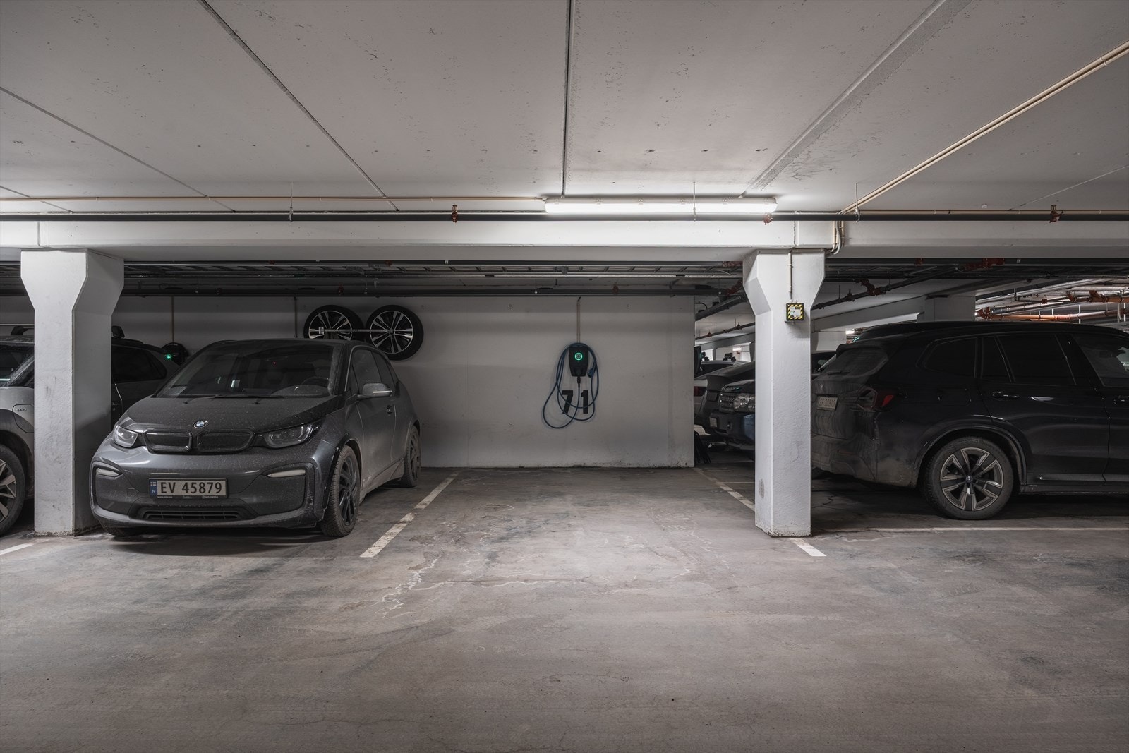 En bred hjørneparkeringsplass i felles garasjeanlegg med installert elbillader medfølger. Enkel adkomst og godt med plass! Galleribilde