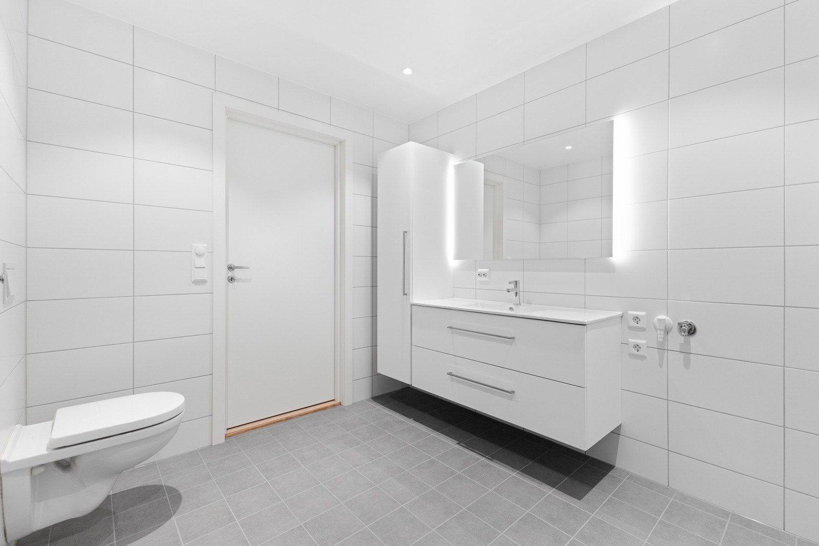 Pent bad som er innredet med baderomsinnredning med vask, speil og høyskap, toalett, dusjnisje med innfellbare glassdører, samt opplegg for vaskemaskin. Galleribilde