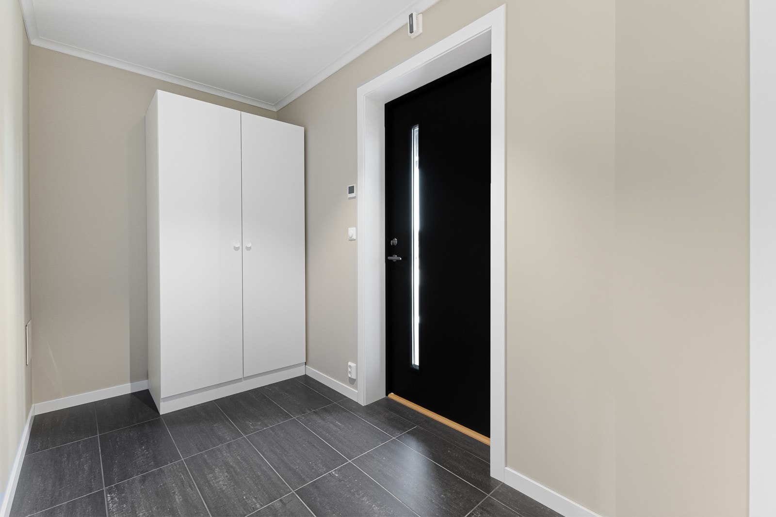 Innbydende inngangsparti og romslig gang med garderobeskap og flislagt gulv med varme. Galleribilde