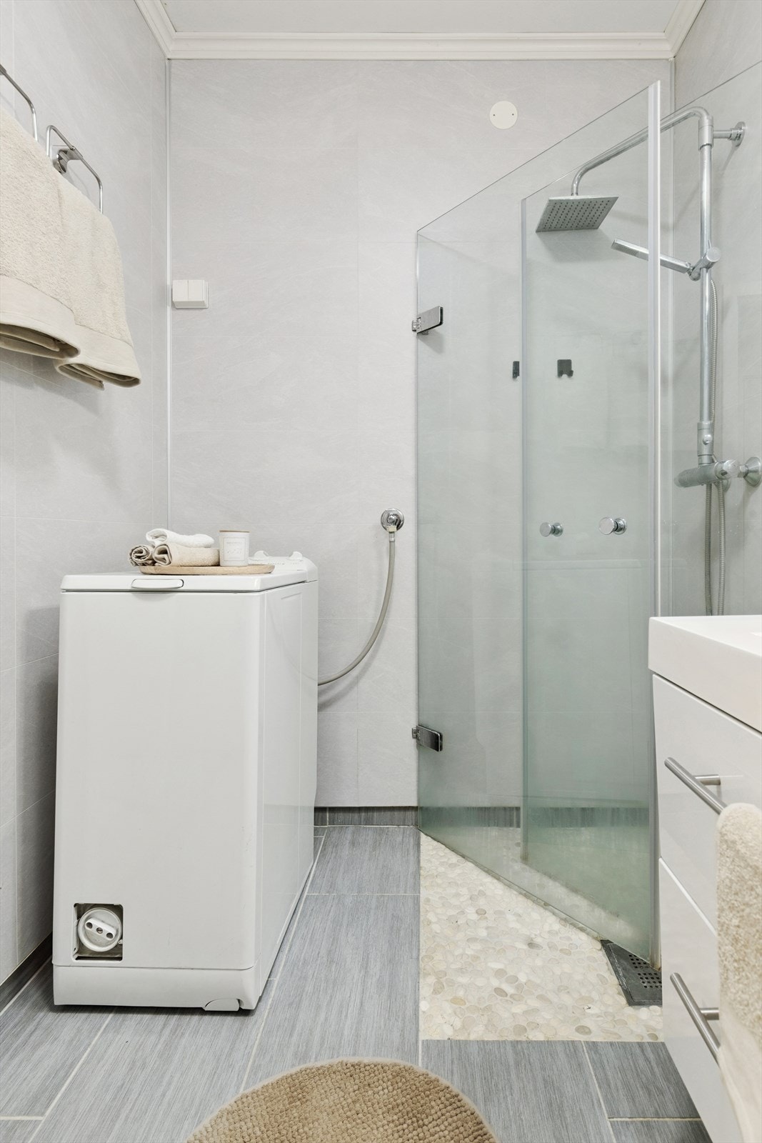 Her er det et dusjhjørne med innfellbare glassdører og opplegg for vaskemaskin. Galleribilde