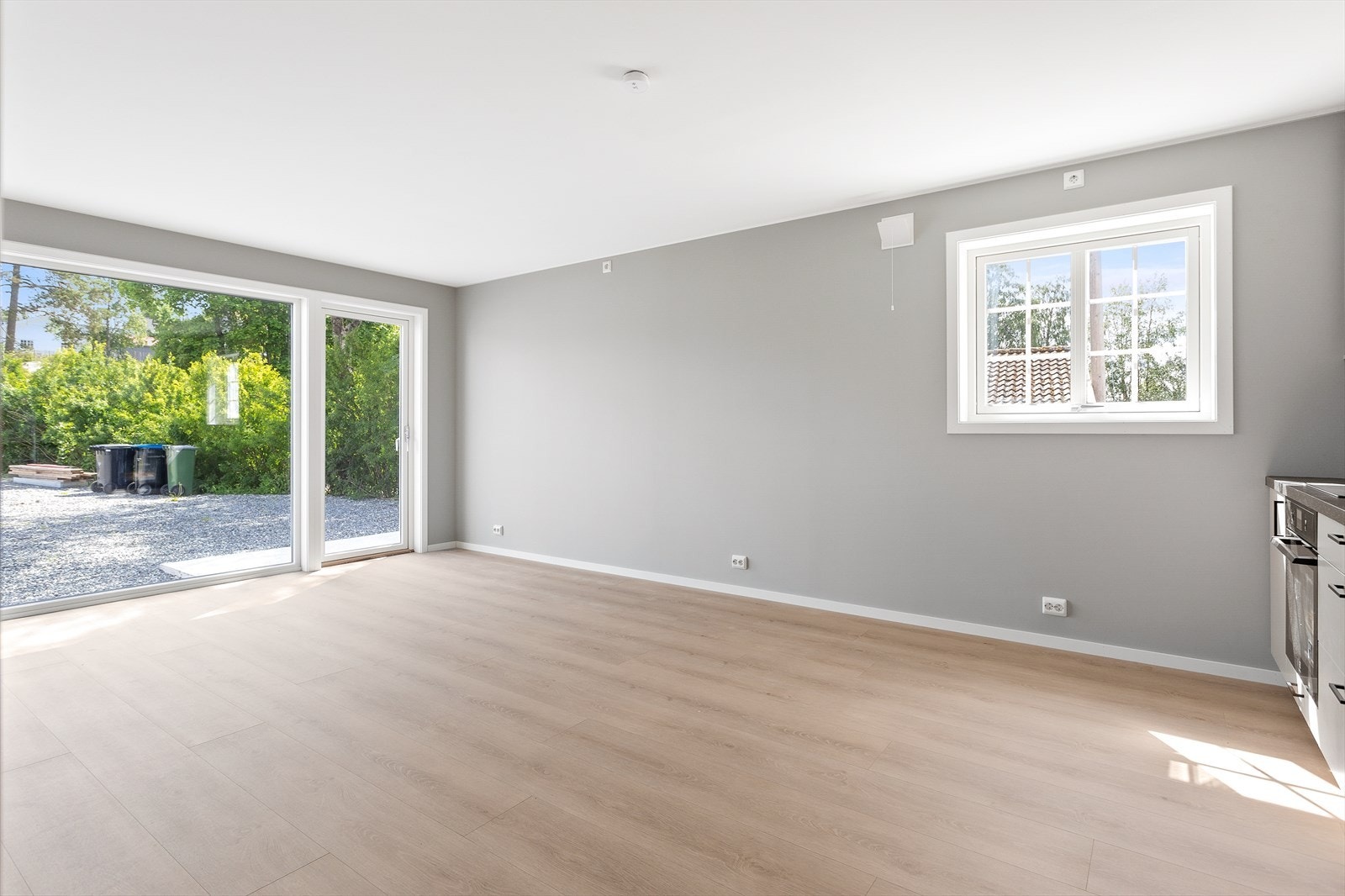 Store vindusflater fra gulv til tak slipper inn rikelig med naturlig lys og gir rommet en god romfølelse. Her er det også utgang til en solrik terrasse via glassdør - et naturlig samlingspunkt på varme dager. Galleribilde