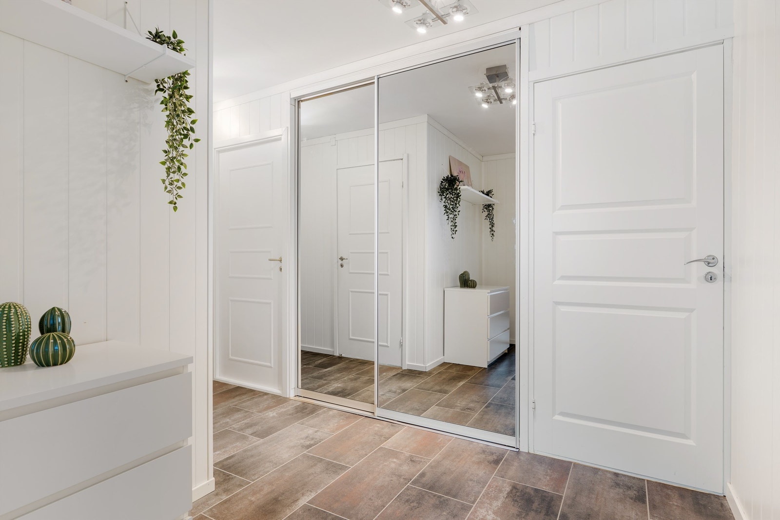 Speilskyvedørsgarderobe gir en ryddig og praktisk løsning med ytterligere oppbevaringsmuligheter. Galleribilde