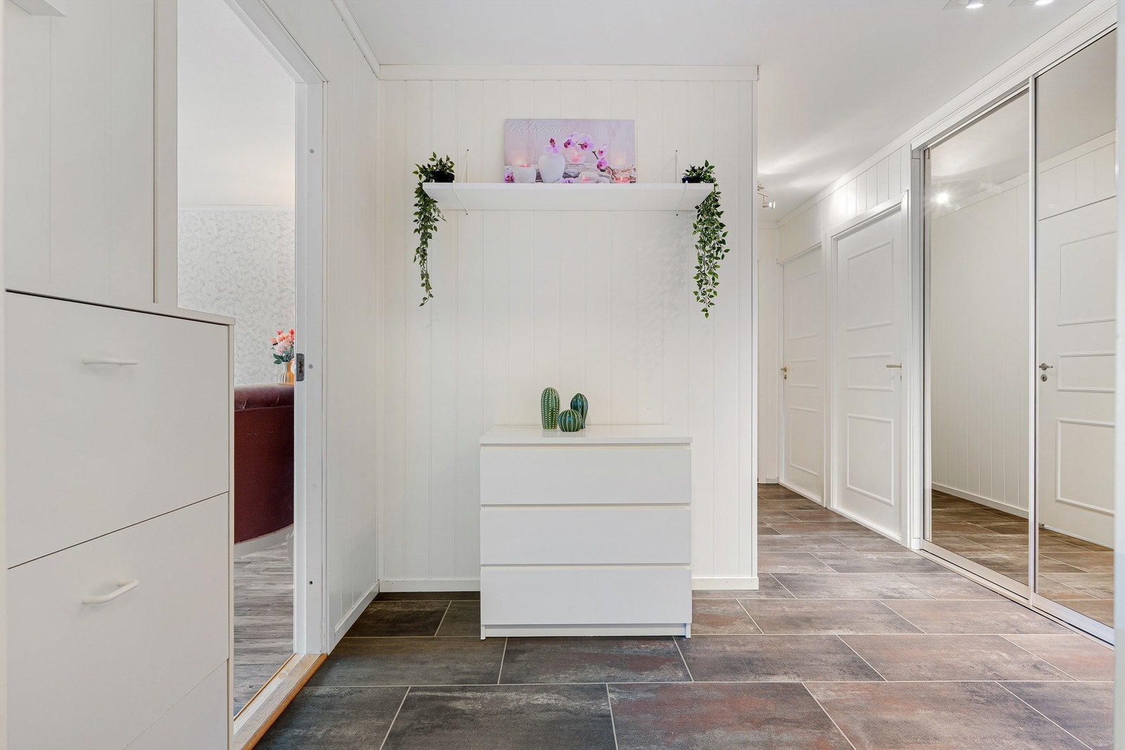 Romslig og lys entré med god plass til oppbevaring av yttertøy og sko. Leiligheten disponerer videre fire boder, hvorav en befinner seg på balkongen, to i 1. etasje og en i trapperom i samme etasje som leiligheten. Galleribilde