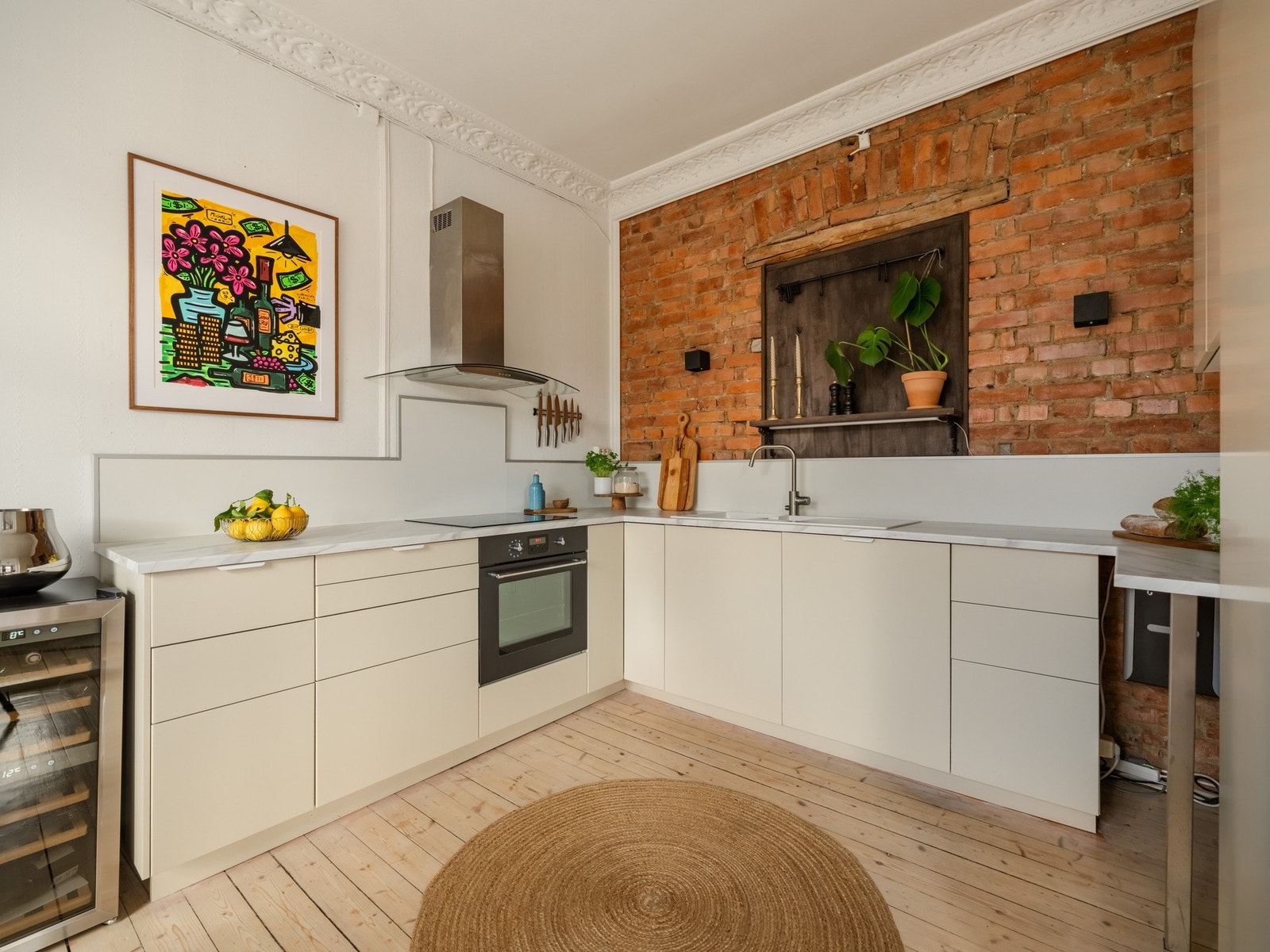 Innredningen består av slette fronter og benkeplater av laminat. Hvitevarer, som integrert stekeovn, induksjonstopp og oppvaskmaskin, følger med i salget. Galleribilde